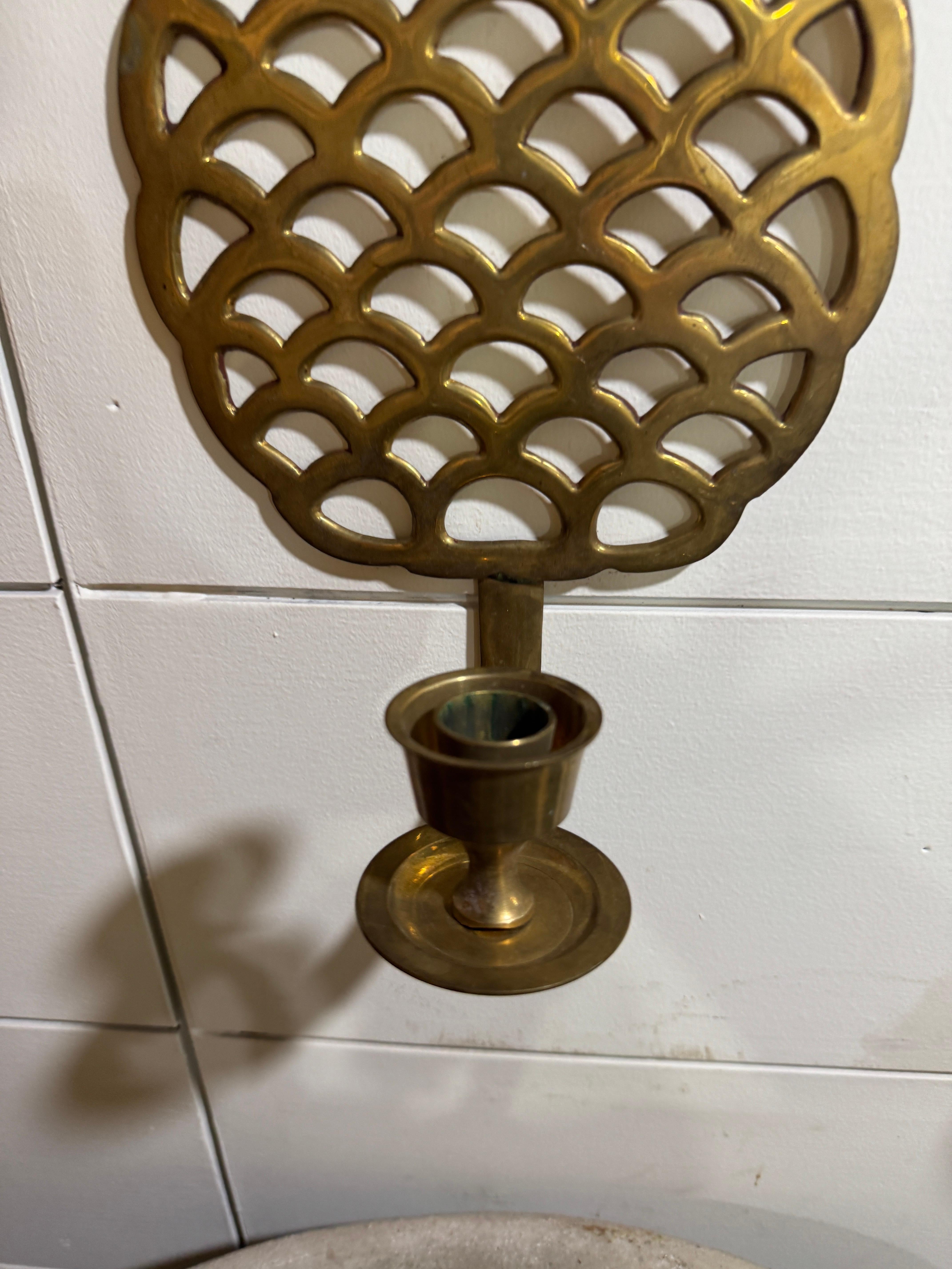 Ajoutez une touche d'élégance intemporelle à votre intérieur avec cette exquise paire d'appliques murales ananas en laiton vintage. Fabriquées avec des détails ajourés complexes, ces appliques présentent un motif d'ananas classique, symbole
