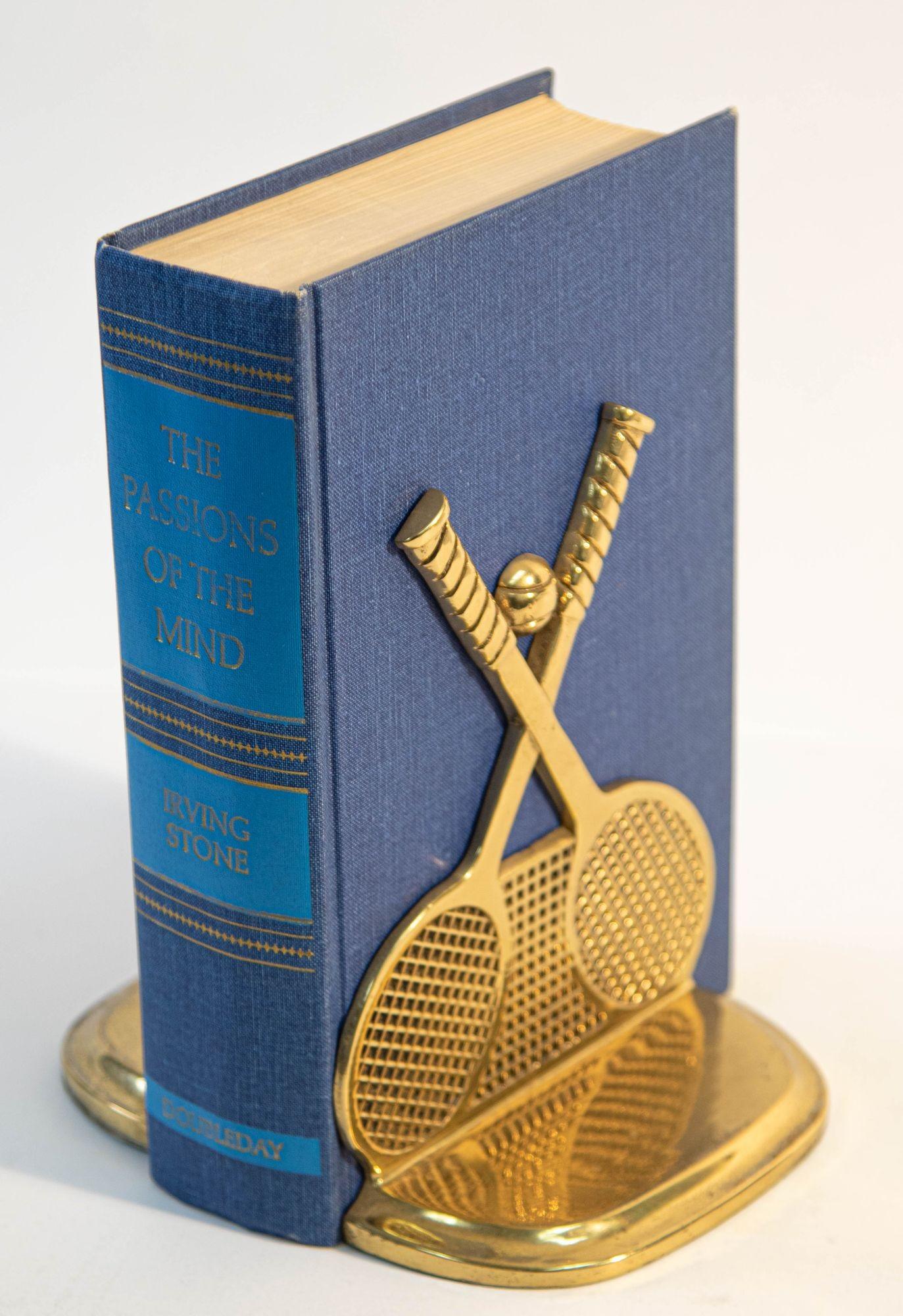 Pair of vintage brass tennis racket and ball bookends.
This pair of vintage cast brass bookends feature a tennis racquet sculptures on each with a ball in front of a tennis net.
Vintage from the late 1970s-1980s these brass tennis racket and ball