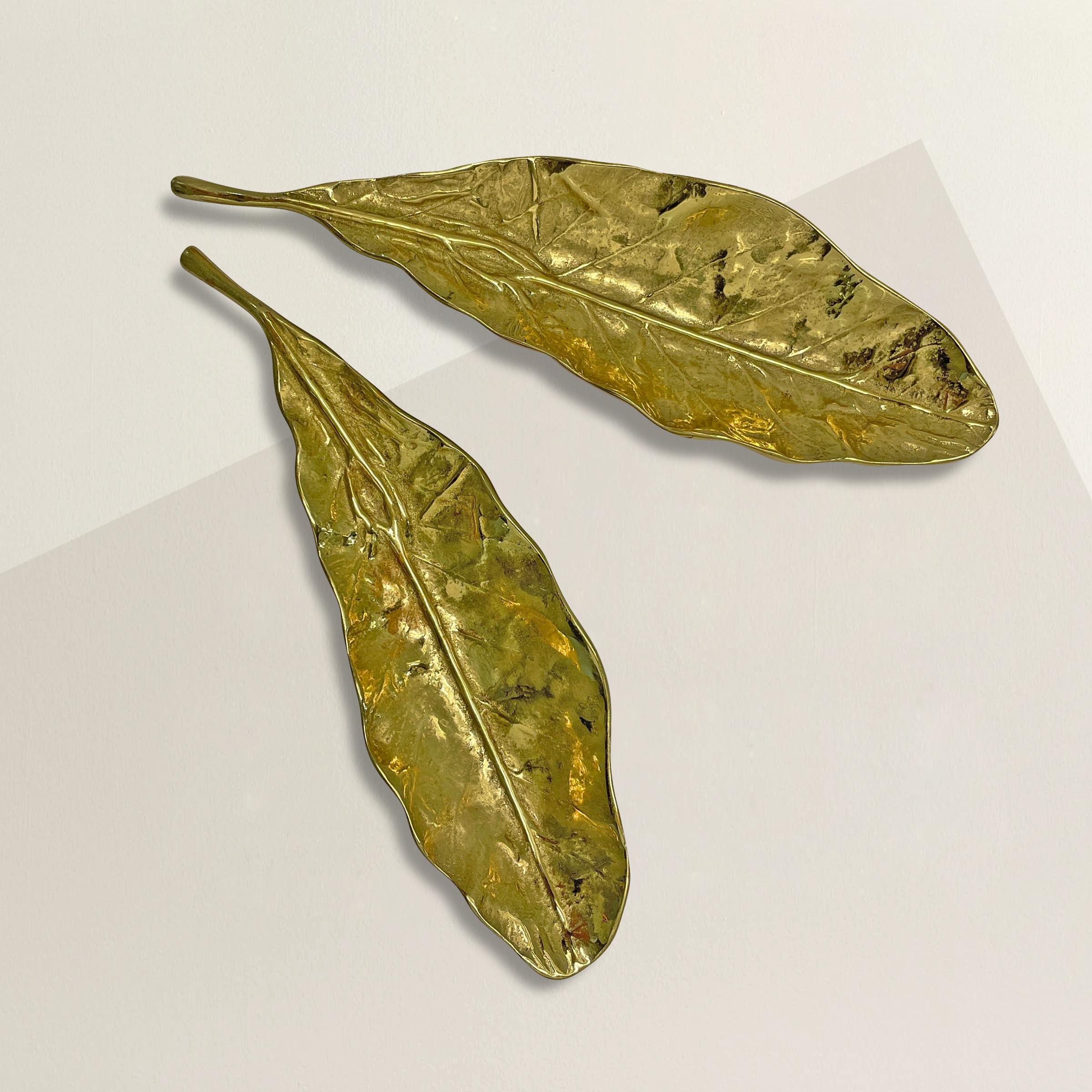 A pair of chic vintage American solid cast brass tobacco leaf dishes, perfect for holding paperclips, pens, chocolates, or any other vices you may have.