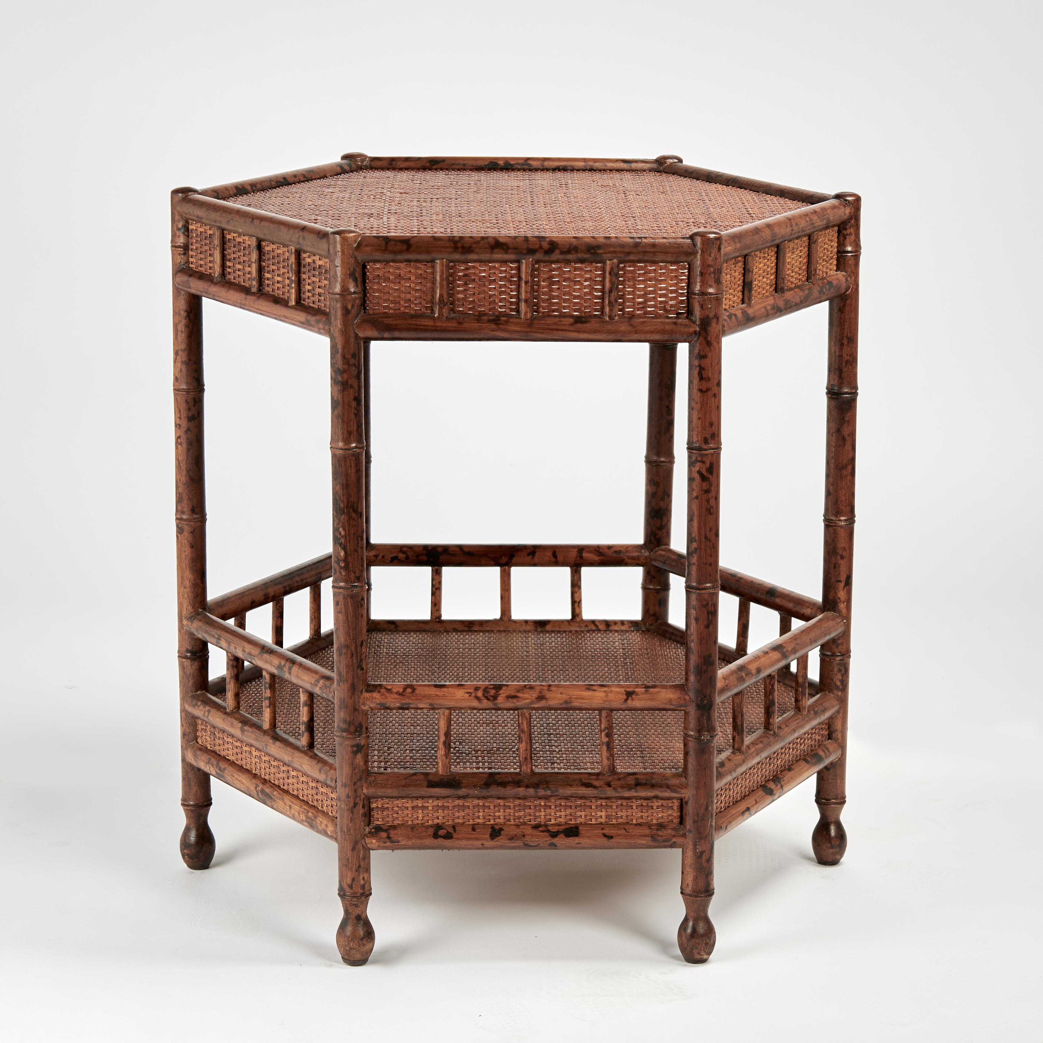 Standout pair of vintage British colonial stands crafted with faux bamboo wood frames having hexagon tops with grasscloth panels on the tops, skirts and lower tiers set on turned feet.