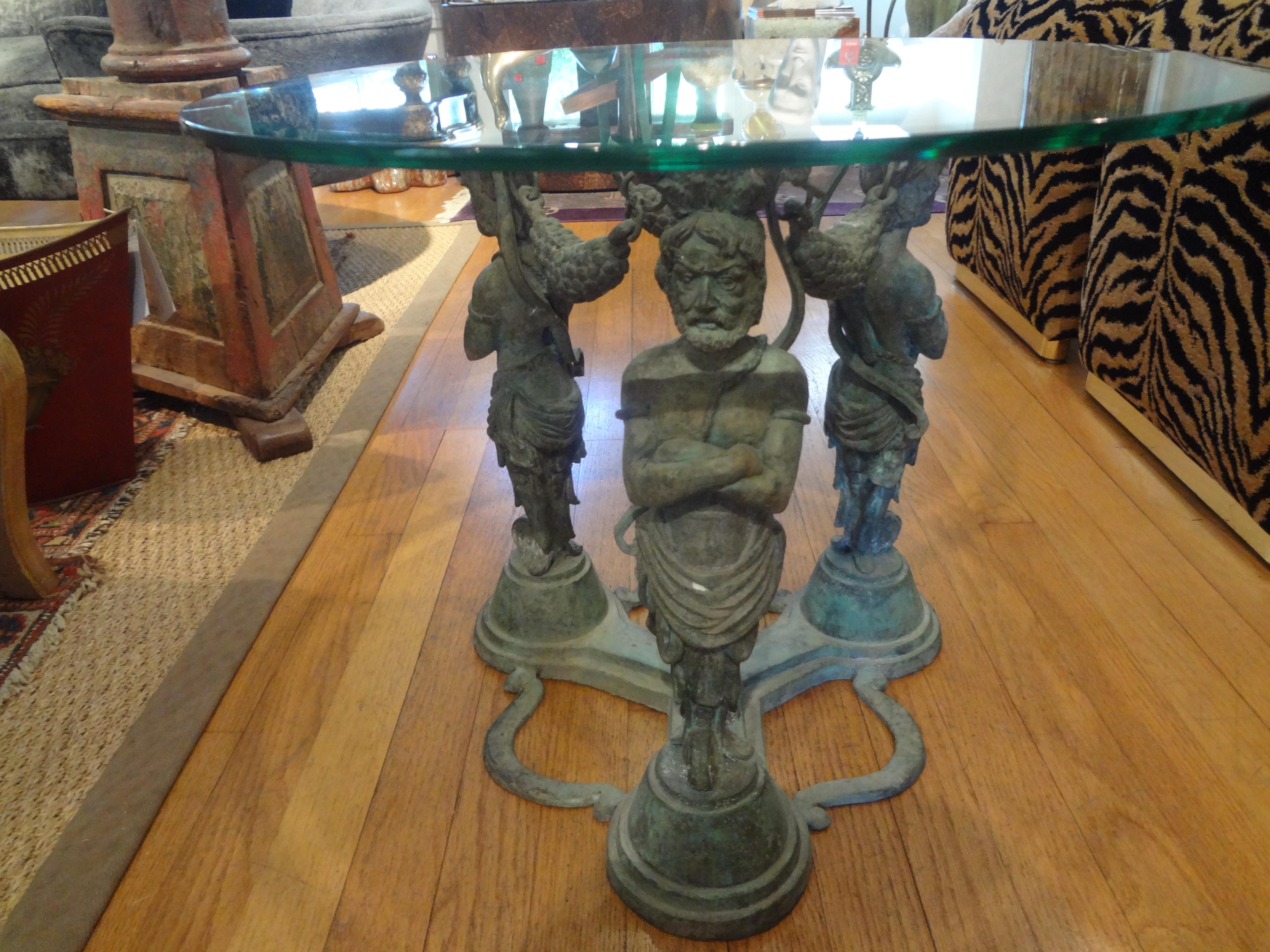 Pair of vintage bronze Grecian inspired tables. This matching pair of Greco-Roman style tables, side tables, gueridons, or drink tables have round beveled glass tops and would work well in many interiors. Stunning!