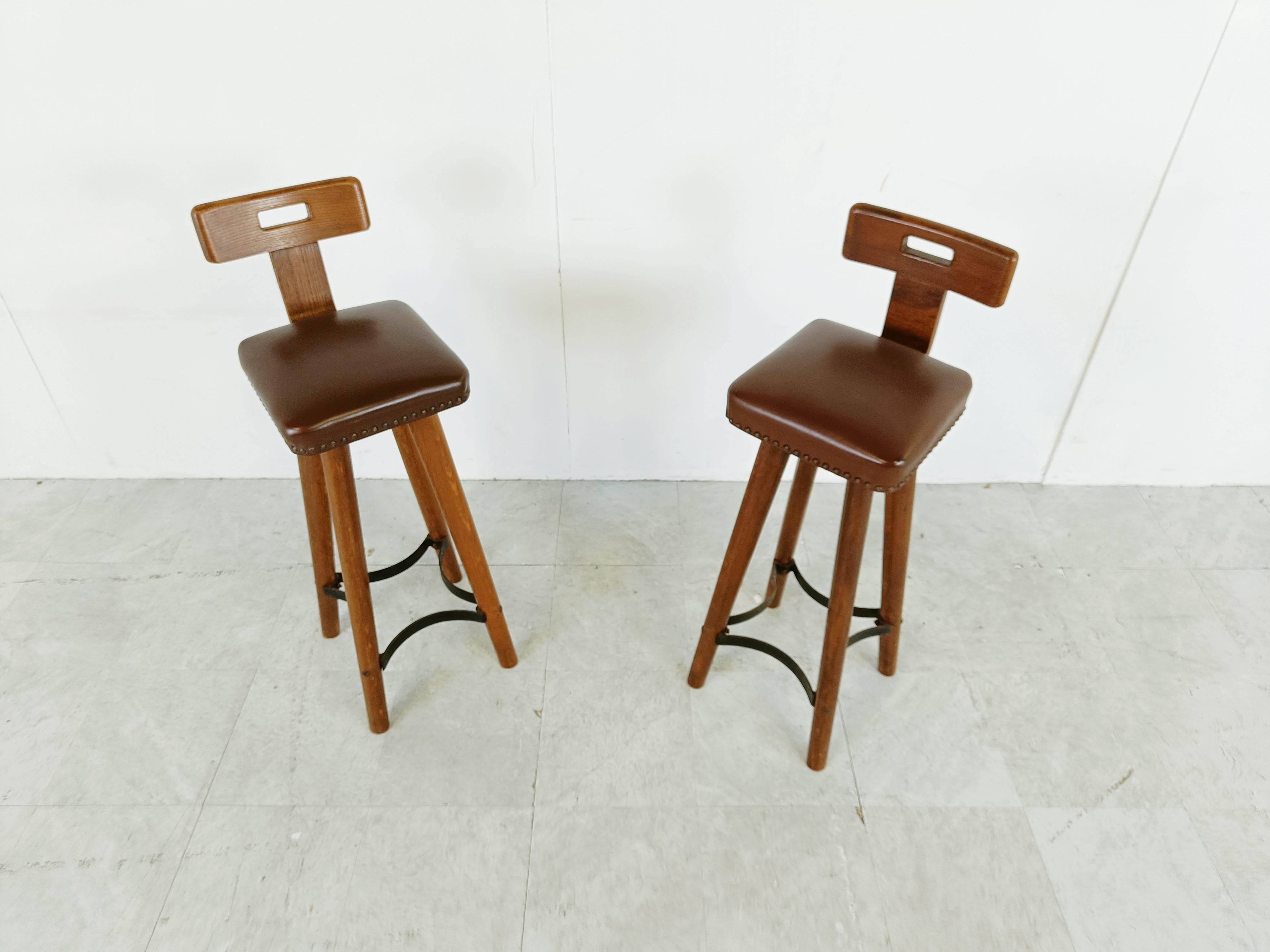 Mid century brutalist bar stools with elegant backrests and leatherette seats.

Metal footrests.

1960s - Belgium

Dimensions:
Width: 30cm/11.81
