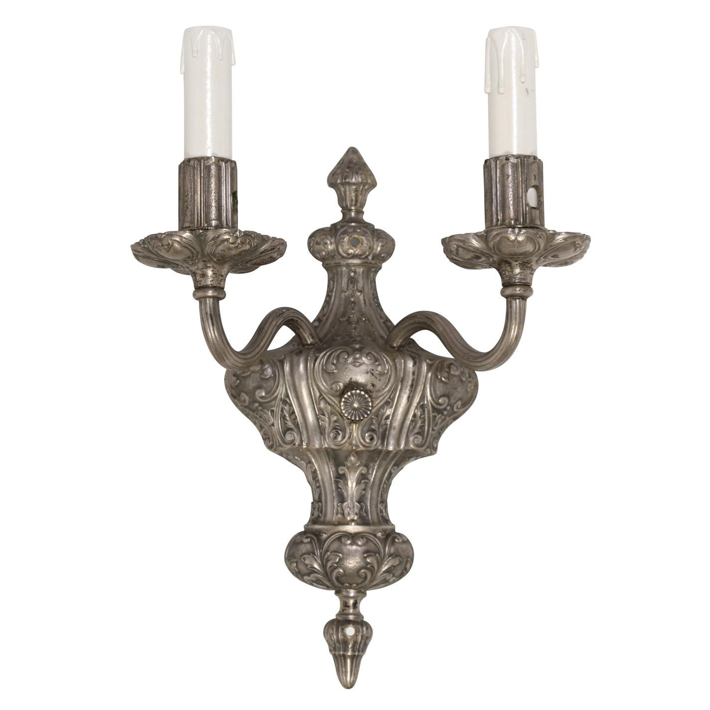 A pair of caldwell carved silver tone double arm wall sconces.