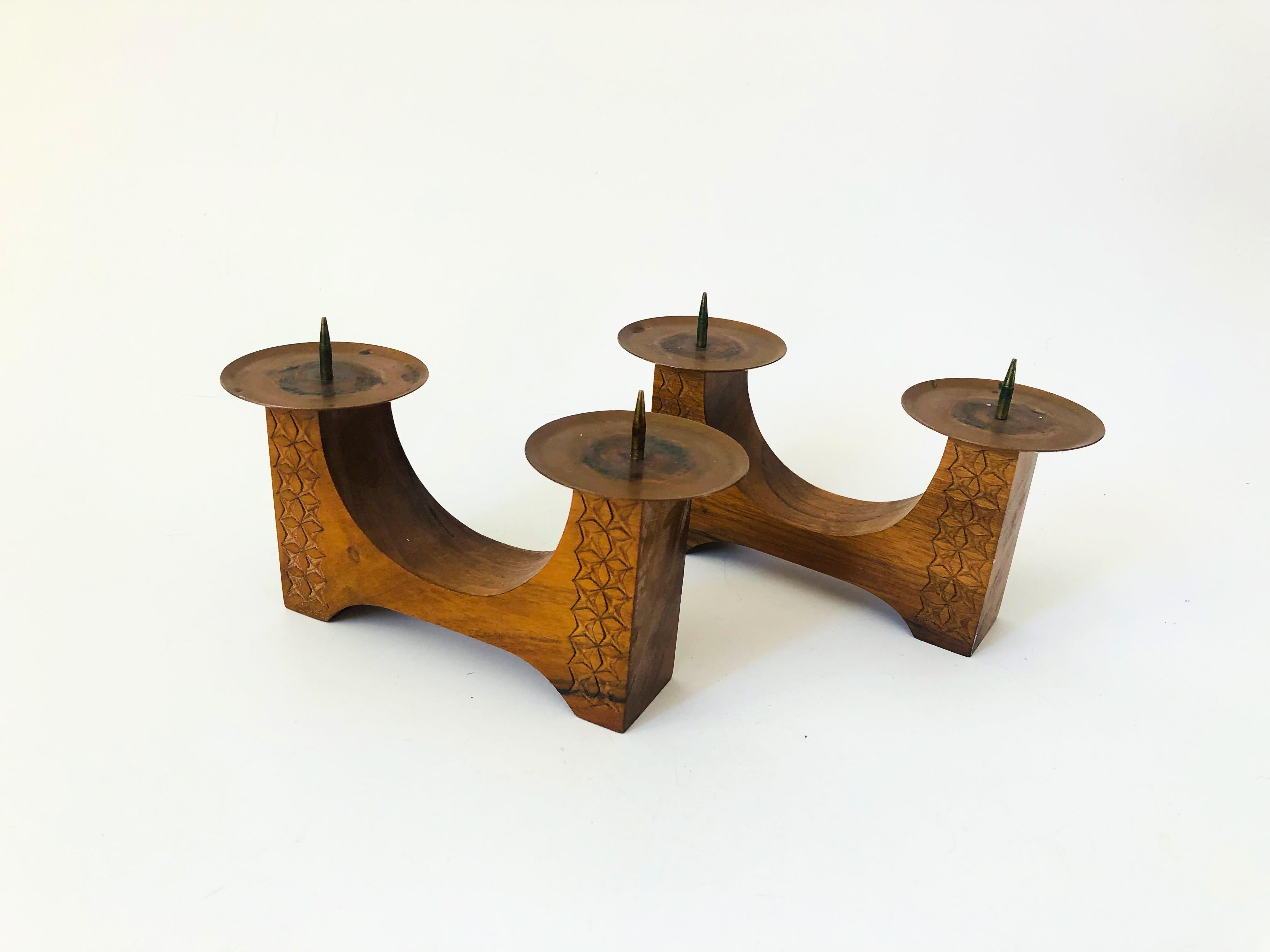A pair of vintage wood candle holders. Each has a lovely carved design on the sides with copper tops for holding 2 candles each.
 