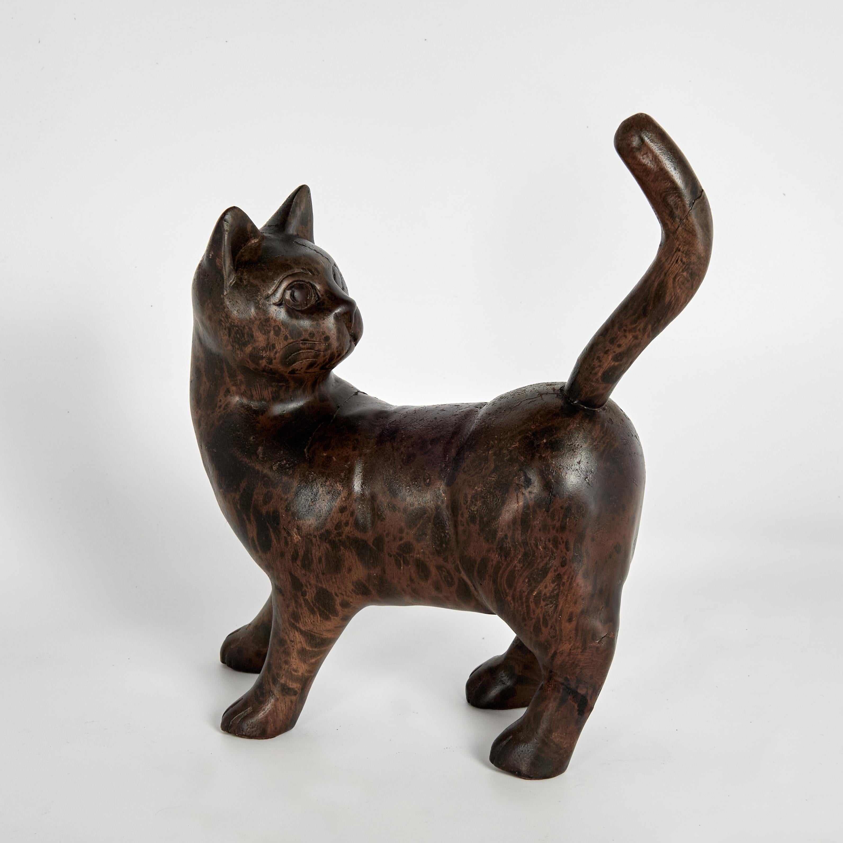 Impressionante coppia di sculture o figure di gatti sapientemente scolpite a mano in legno con forme sorprendentemente realistiche, atteggiamenti e una lussureggiante finitura maculata simile al bronzo. 