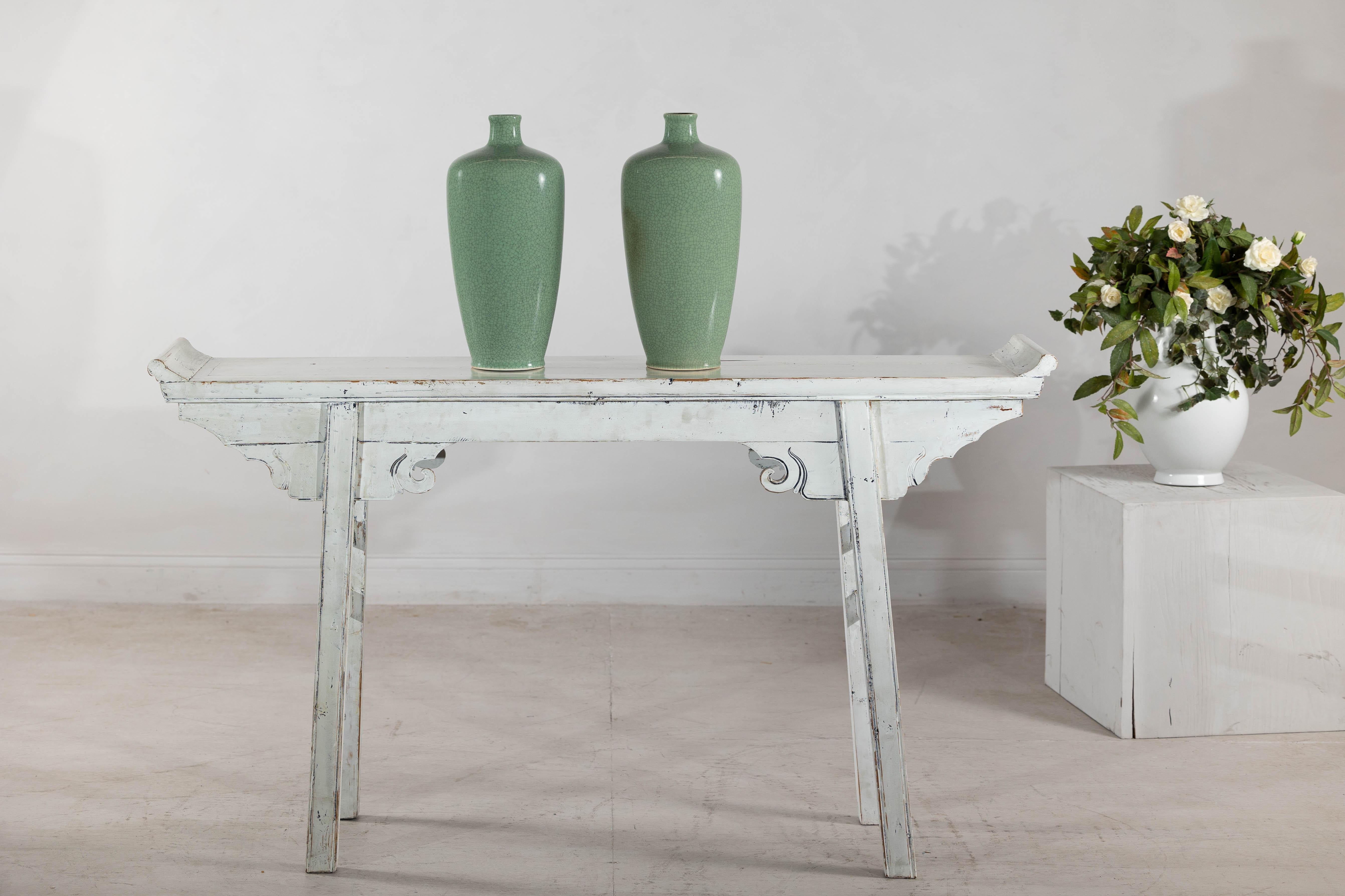Una coppia di vasi in porcellana vintage con un'intramontabile smaltatura celadon crackle, le cui eleganti silhouette riprendono la classica forma meiping. Il morbido smalto verde, con la sua sottile rete di craquelure, esalta la superficie con