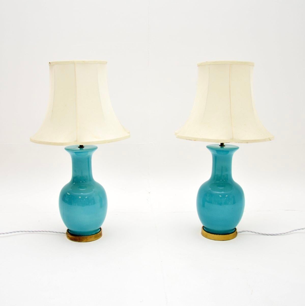 A stunning pair of vintage ceramic and brass table lamps. They were made in England, and date from around the 1960’s.

The ceramic is the most beautiful shade of turquoise blue, accentuated by a brass rim around the lower edge. They are of great
