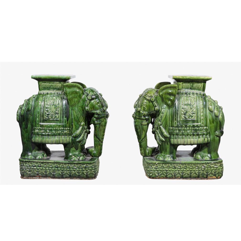 Pair of Vintage Ceramic Elephant Stands, South Vietnam. Molded ceramic elephant stands with a square howdah serving as the table surface area. The elephants are  caparisoned with a large saddle blanket. The short upright ears indicates elephants of