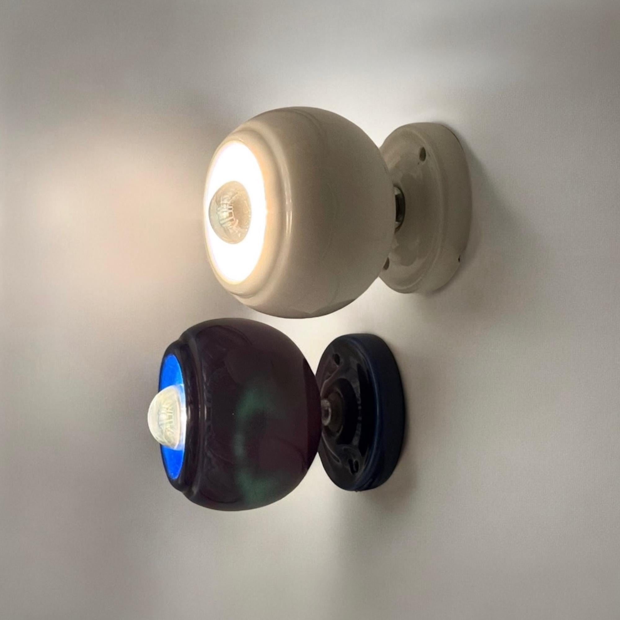 Enhance your space with this rare pair of 70s ceramic lamps, a striking example of Italian design and retro aesthetics. Crafted in Italy during the 1970s, these lamps feature a glossy ceramic body in deep blue and crisp white, creating a bold yet