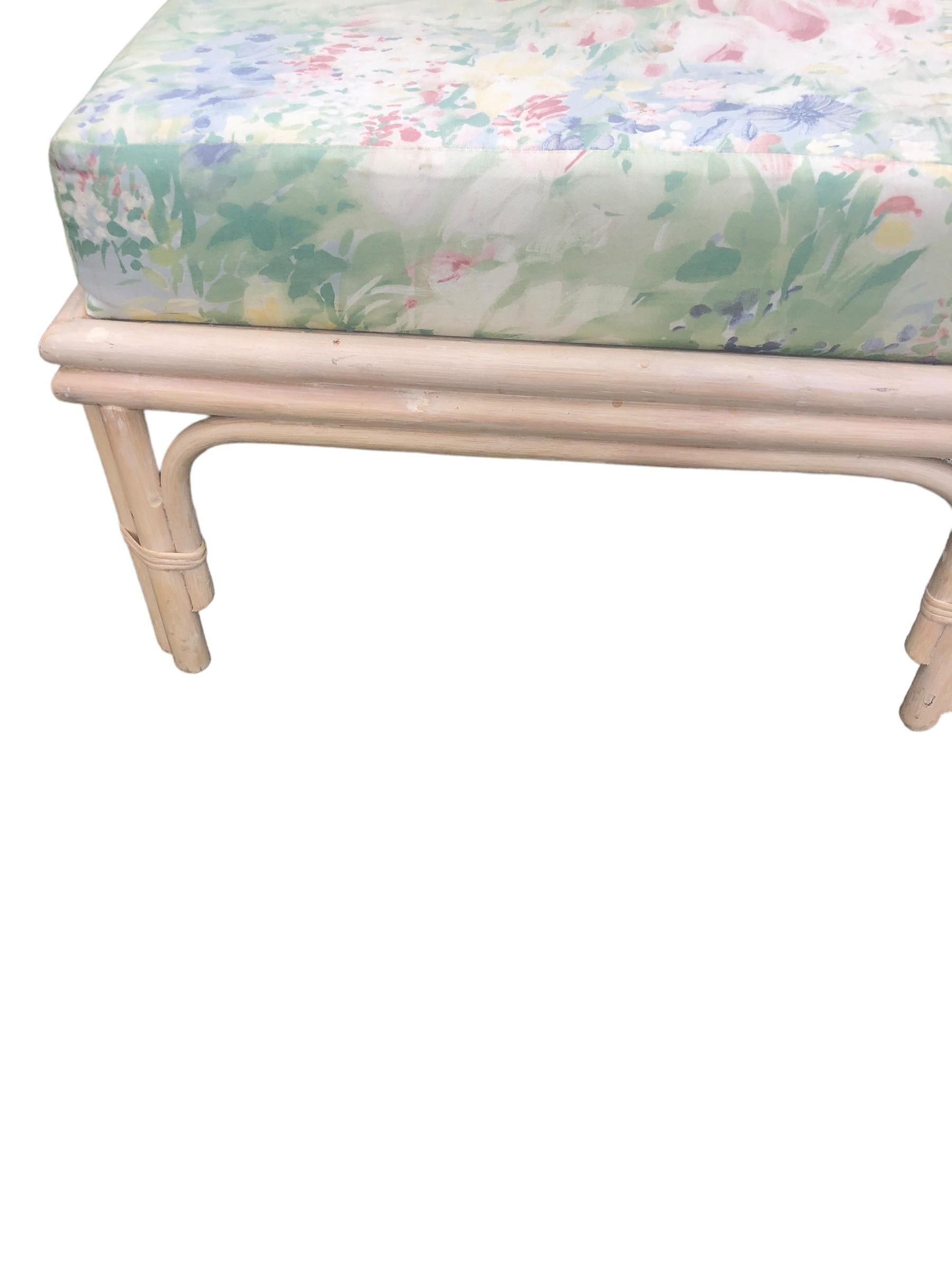 Ein Paar Rattanstühle im Vintage-Stil und ein passender Fußhocker von Ficks Reed. Äußerst bequem und großzügig dimensioniert, mit geblümten Polsterkissen, die aufgrund von Abnutzung und Verblassen ausgetauscht werden müssen. 
Fußhocker misst 25 x21