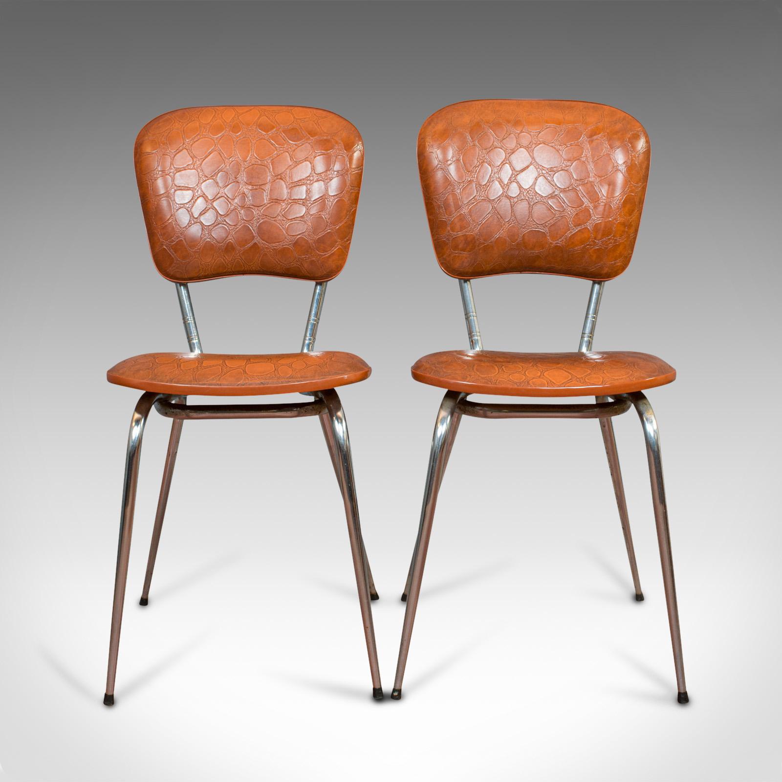 This is a pair of vintage chairs. A French, faux crocodile upholstered desk or breakfast chair, dating to the mid-20th century, circa 1960.

Rich tan hues and appealing modern form
Displays a desirable aged patina
Comfortable, well padded seat