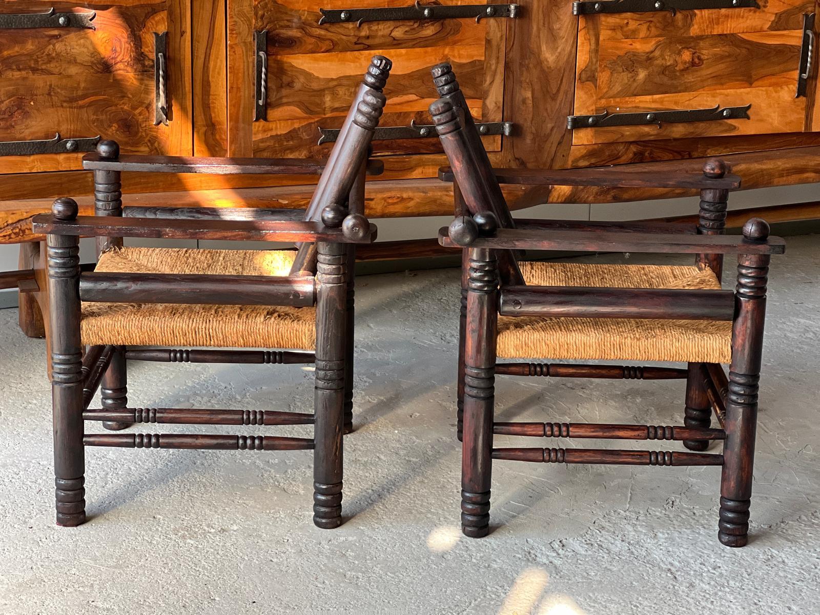 Paire de fauteuils vintage Charles Dudouyt en bois tourné et teinté, travail français années 1940
Dossier articulé inclinable 
Siège en paille 
Bon état