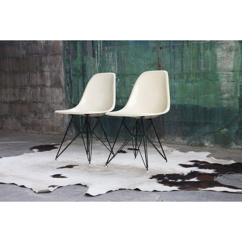 These very exciting original early vintage iconic pair of Mid-Century side chairs by Herman Miller feature the Classic Charles Eames Eiffel Tower base, molded fiberglass seats, and Herman Miller medallion and labels. Excellent for side chairs,