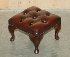 par de taburetes antiguos de piel de becerro con respaldo en forma de ala de chesterfield tapizados