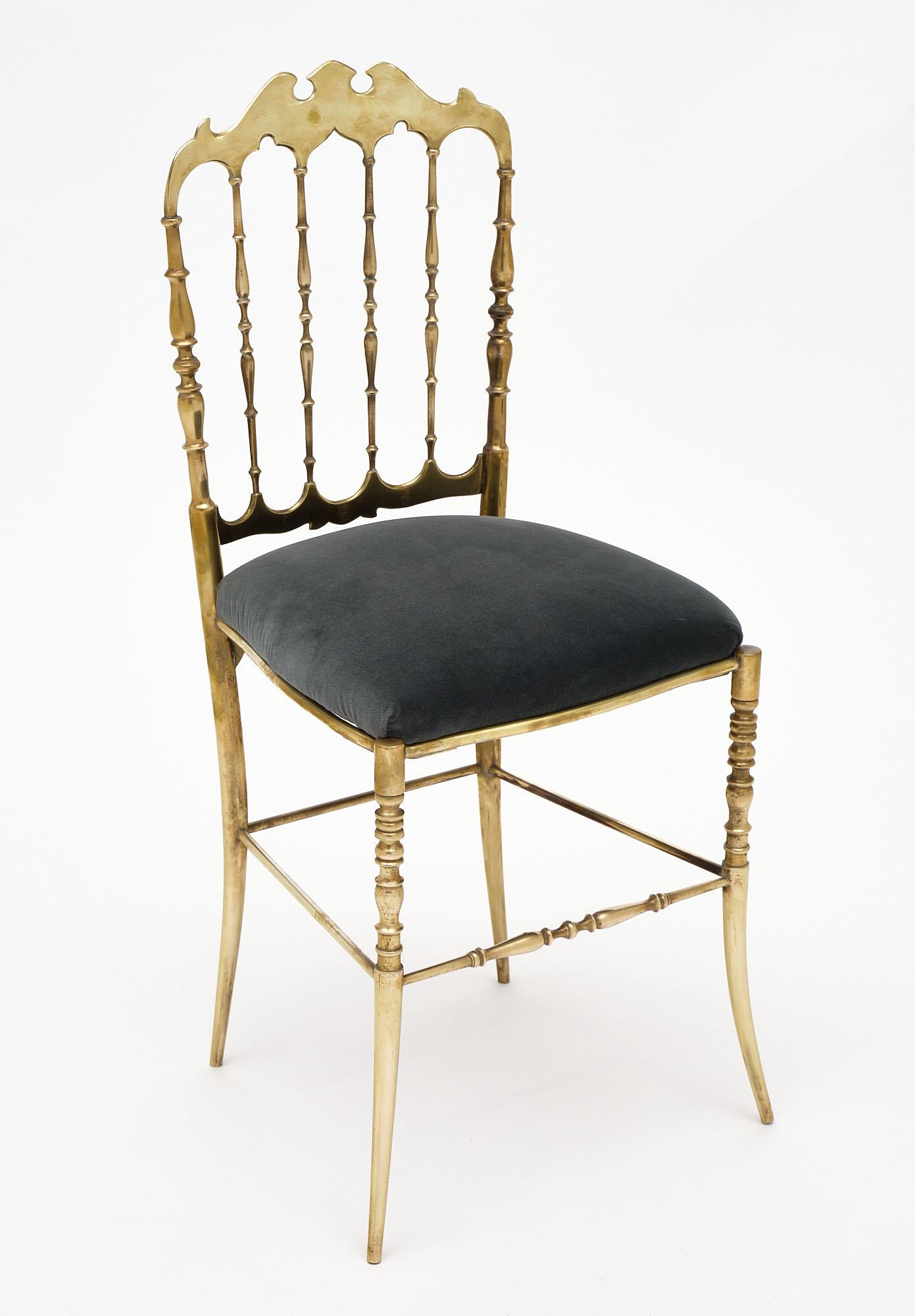 Pair of chairs, of solid gilded brass, Italian, with newly upholstered seats in a gray velvet blend. Chiavari chairs are named for the Italian city where they originated. This little town, located between Genoa and the Cinque Terre; began producing