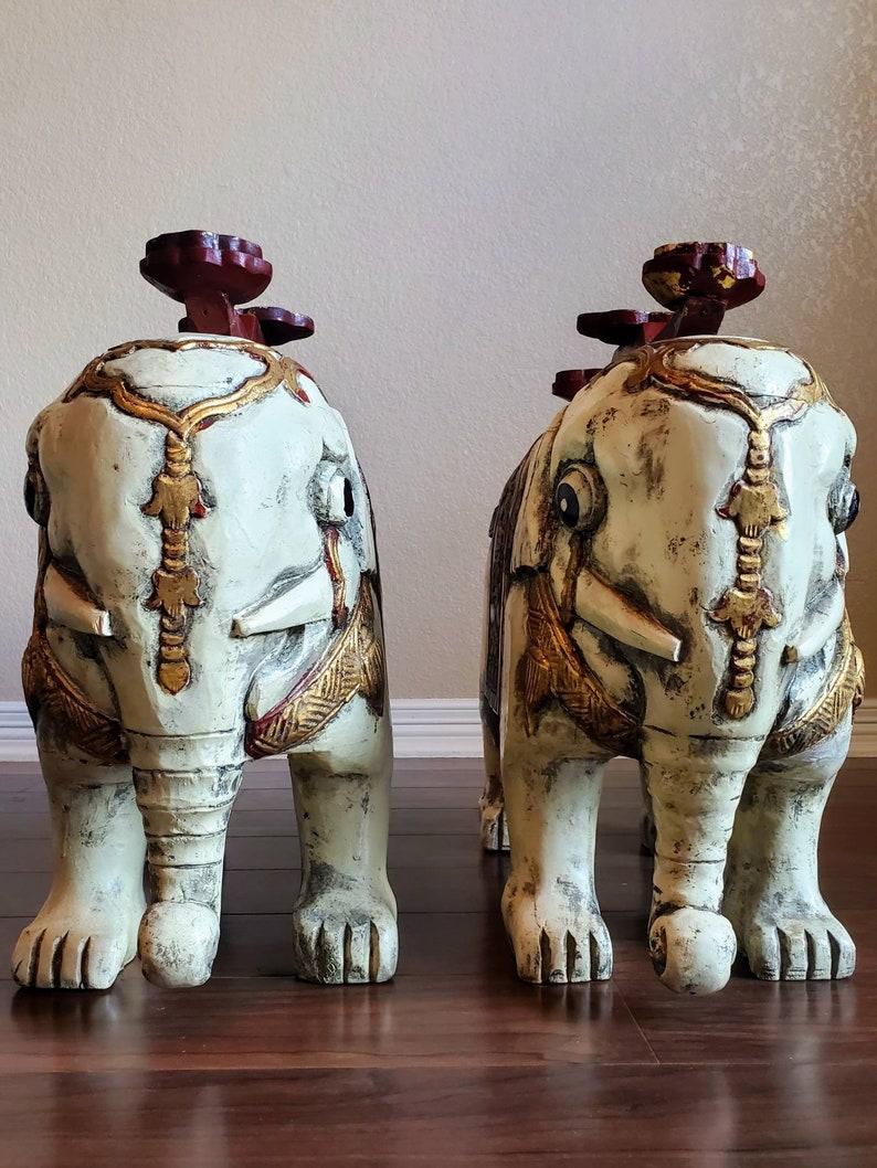 An exceptional pair of Chinese hand carved wooded statues / stands. Whimsical, wonderfully detailed, figural, each in the form of an Asian elephant, painted white, forward facing, having ornate gilt gold accents including fire breathing dragon,