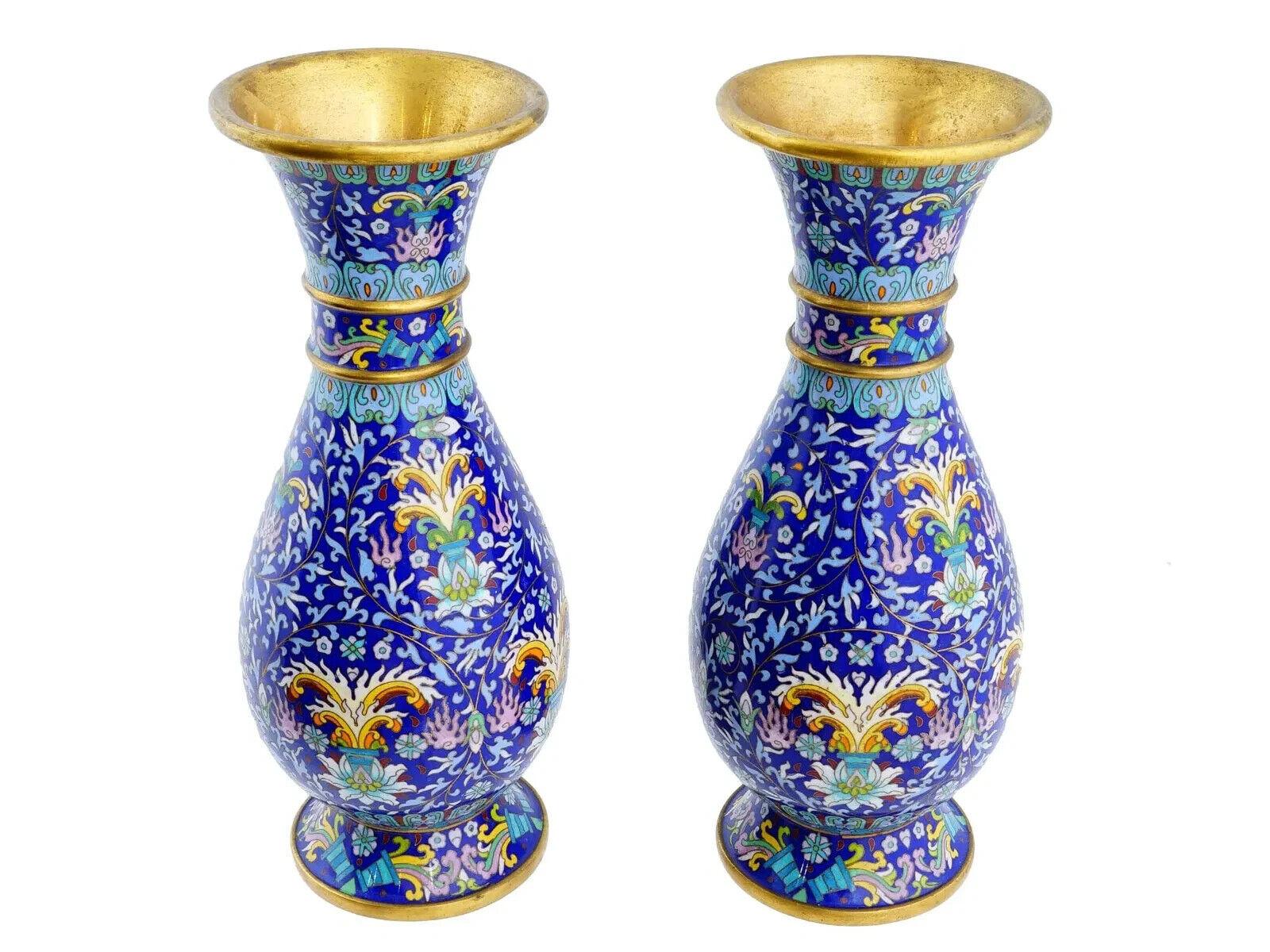 Una coppia di  vasi cinesi vintage in smalto cloisonne. Circa metà o fine del XX secolo. I vasi a balaustro sono sollevati su una base e presentano un rigoglioso motivo floreale e fogliare su un elaborato sfondo in cloisonne blu. Accenti in tonalità