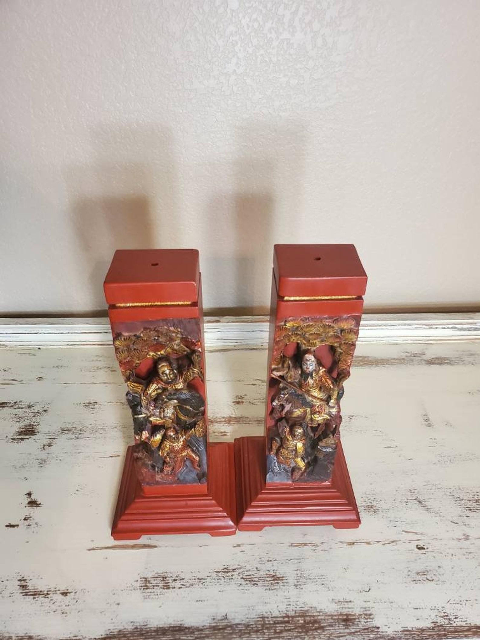 A wonderful pair of antique Chinese red lacquer and gilt gold painted hand carved wooden figural architectural elements turned incense burner pillars. Highly detailed carvings featuring Asian pine tree motif representing longevity, horseback rider