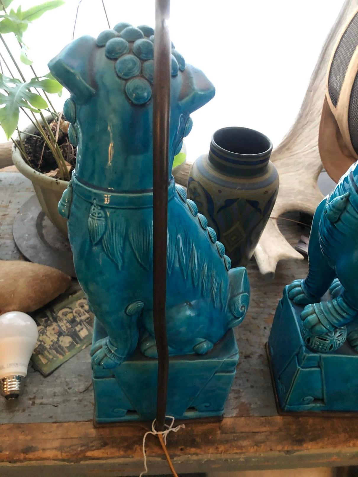 A wonderful pair of vintage Chinese Foo dog statues converted into small table lamps. These dog lamps were the property of Valley Castle in Cornwall Connecticut. 
Fu dogs are actually lions. They originated in China, shi, meaning lion, yet they