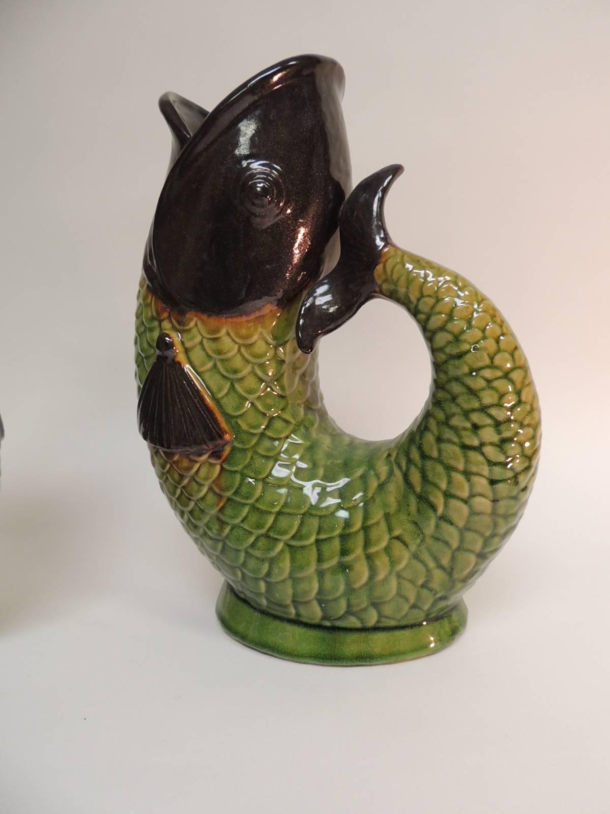 Pair of vintage Chinese hand-painted fish vases
Large Asian flowers or plant vessels. Chinese export hand painted ceramic fish vases with handles.  Green and brown scales, fins and mouth details.  Chinese export porcelain includes a wide range of