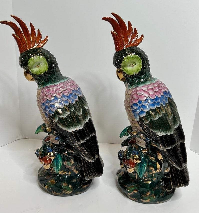 A fabulous pair of vintage Asian multi-colored cockatoo parrot ceramic figurines. 

Finely detailed, richly decorated in bold polychrome decoration and gold gilt accents. Having an orange feathered crest rising from a green head, leading to a