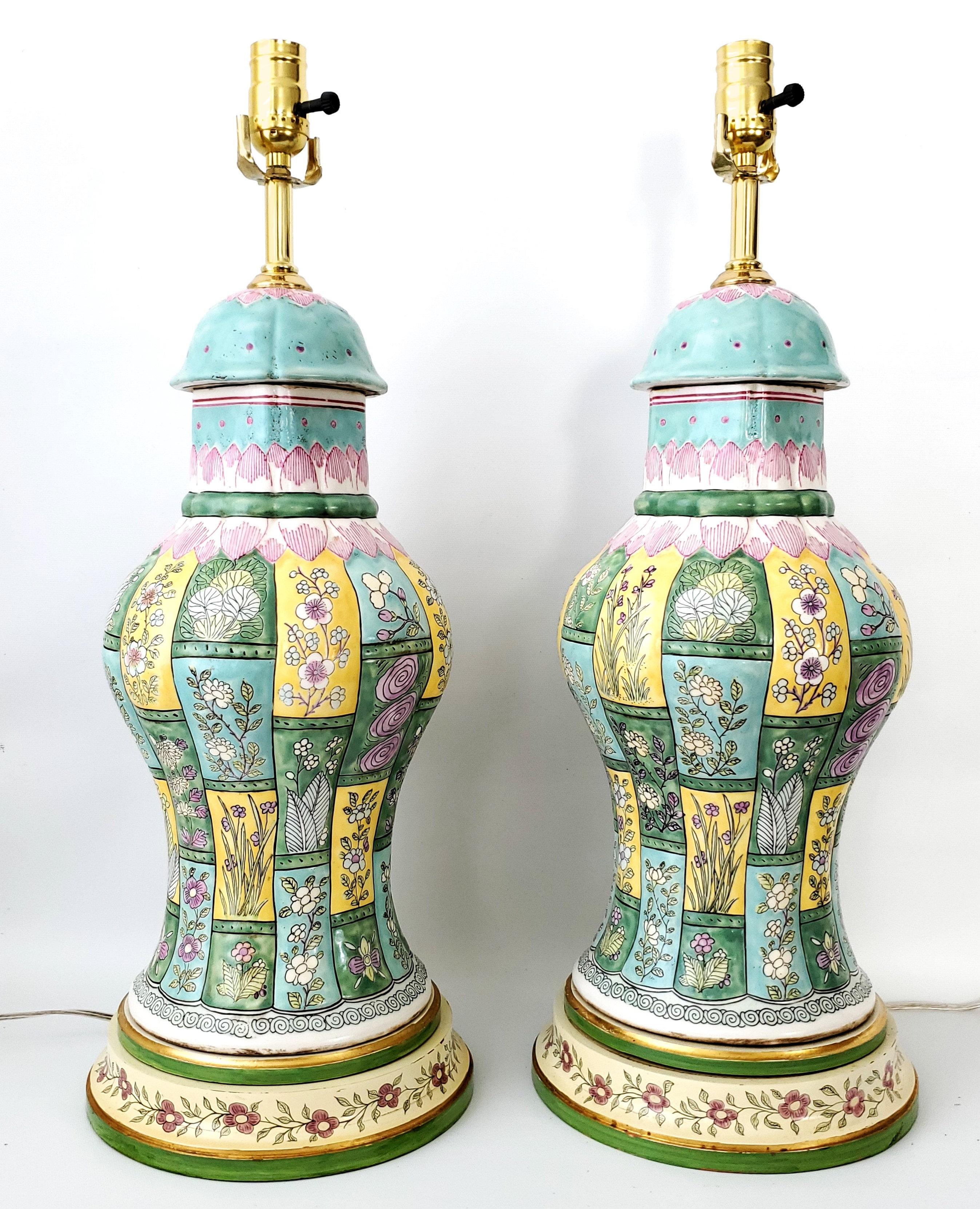 Pair of vintage Chinese porcelain ceramic table lamps baluster shaped with a heavy textural glaze. The bodies of the lamps are thick colorful porcelain with turquoise, pink, yellow, lavender and green floral and geometric designs. The wooden bases