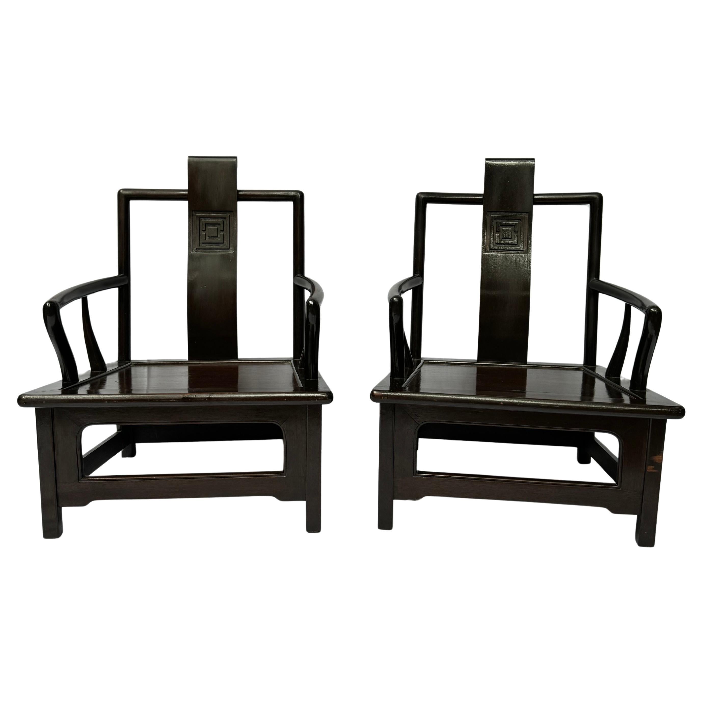 Questa elegante coppia di poltrone in stile cinese degli anni '70 emana una raffinatezza e una maestria senza tempo. Costruite con un ricco legno scuro, queste sedie presentano un equilibrio armonioso tra gli elementi del design tradizionale cinese