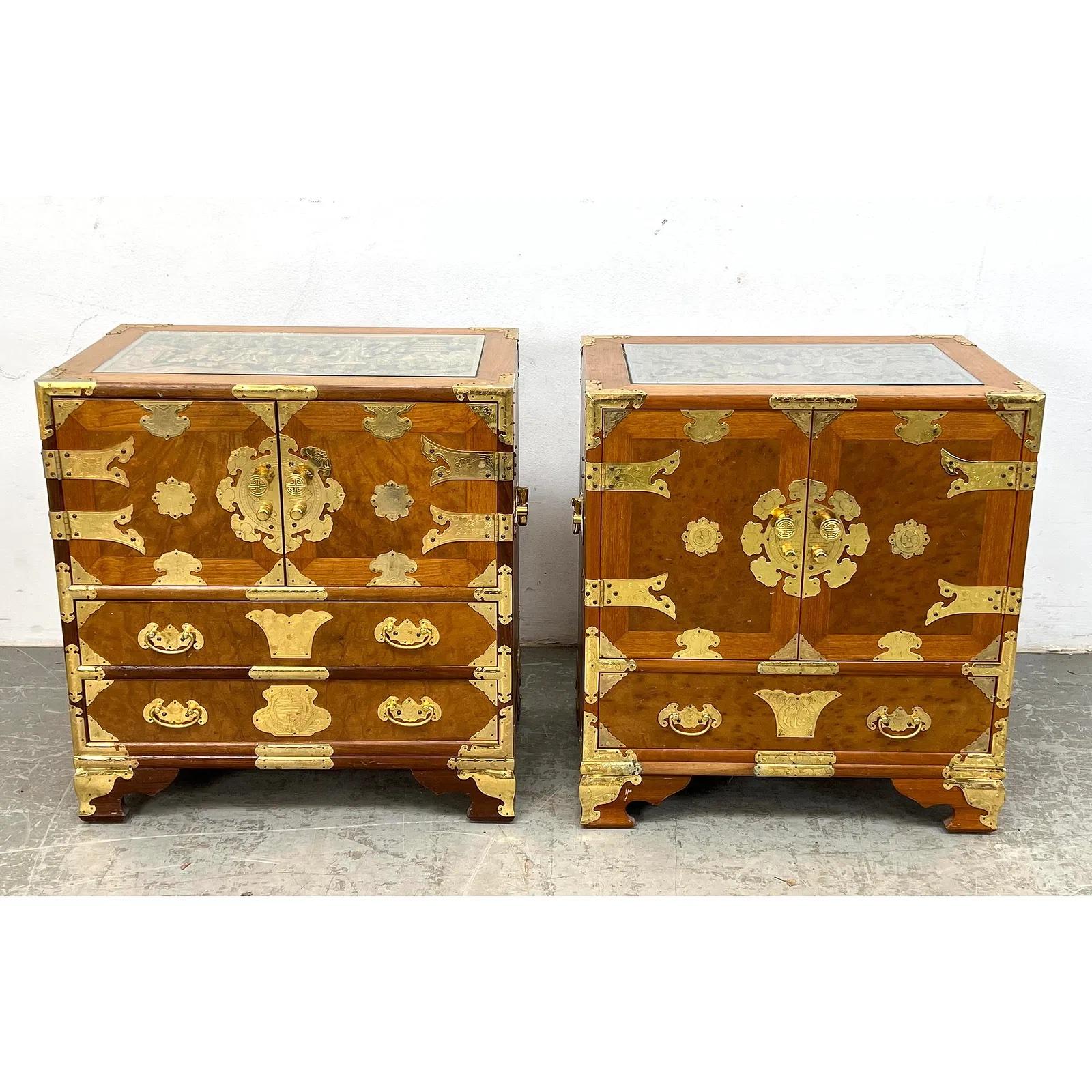 Charmante paire de tables d'appoint de style chinois, avec des plateaux sculptés à la main, des vitres encastrées et des montures en laiton ornées. Chaque pièce comprend des rangements fonctionnels avec des tiroirs et des armoires, mettant en valeur
