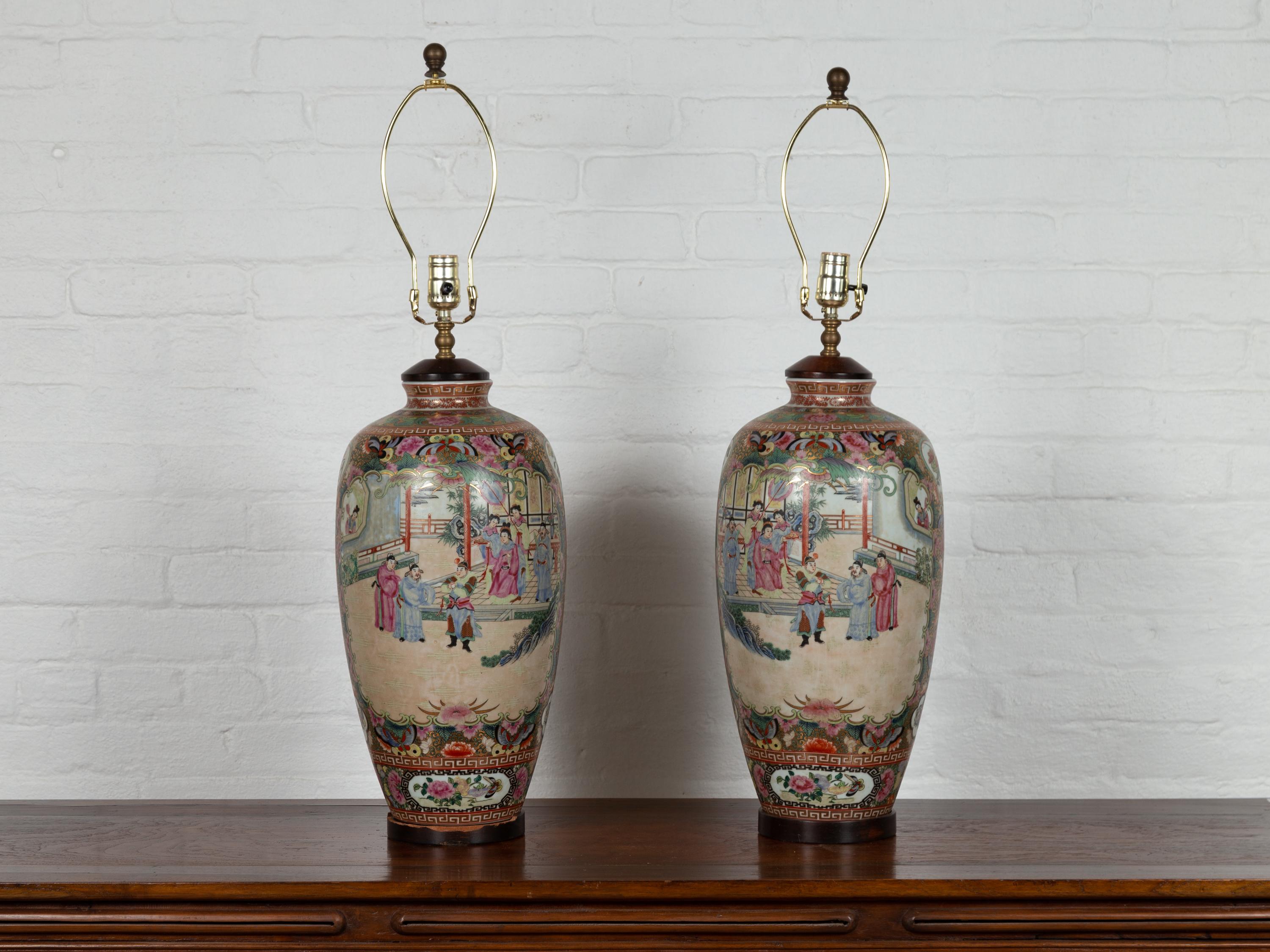 A pair of Chinese vintage rose medallion pattern table lamps from the mid-20th century, depicting temple courtyard scenes. Charming our eyes with their exquisite temple scenes and lovely pastel colors, each of this pair of Chinese table lamps is