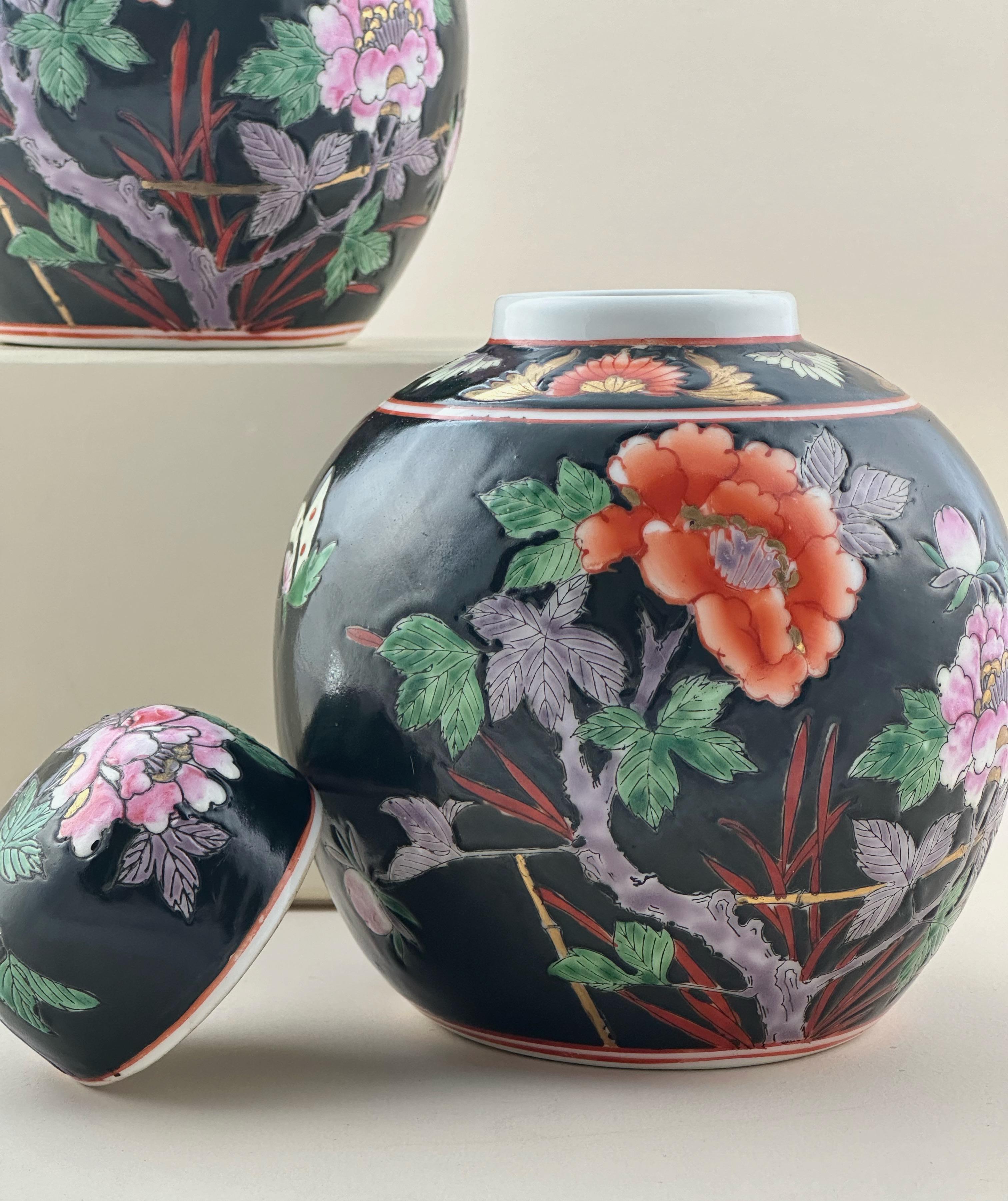 A matching pair of vintage Chinese porcelain ginger jars, hand-crafted in China during the latter half of the 20th century, specifically the 1970s.

Both ginger jars have been decorated in the Famille Noire style, with details inspired by a