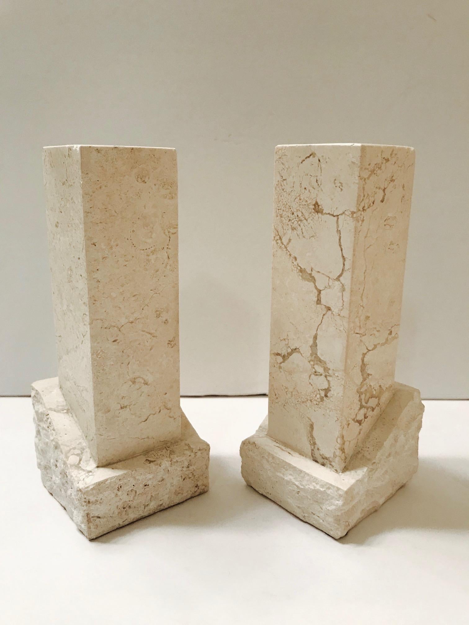 Pair of chic Mid-Century Modern hand carved solid stone candlesticks from the Philippines . Candleholders have chiseled column forms in polished marble with unique veining and extending from natural carved stone bases with rough edges.