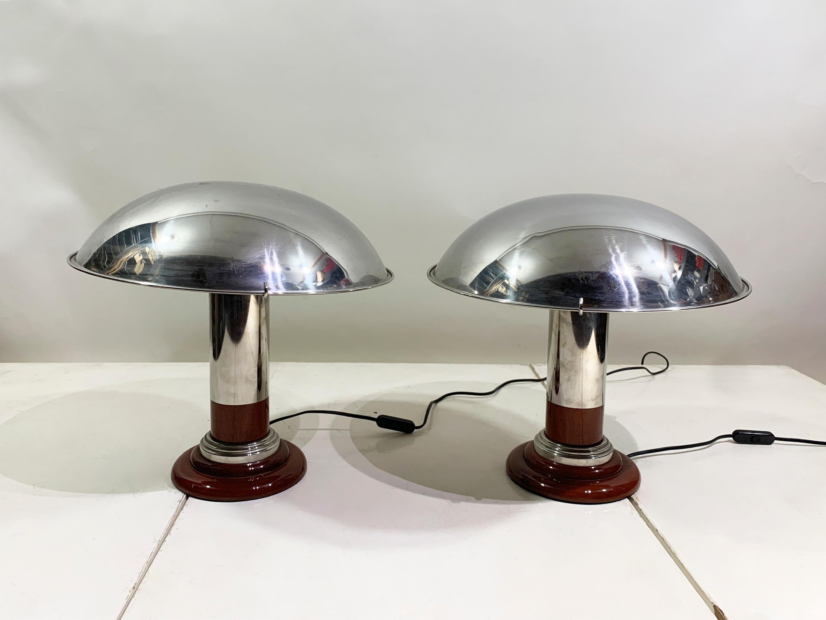 This pair of vintage Art Deco-style table lamps is a stunning example of mid-century design, featuring a beautiful blend of materials and forms. Each lamp showcases a sleek, polished chrome mushroom-shaped shade that provides a soft,