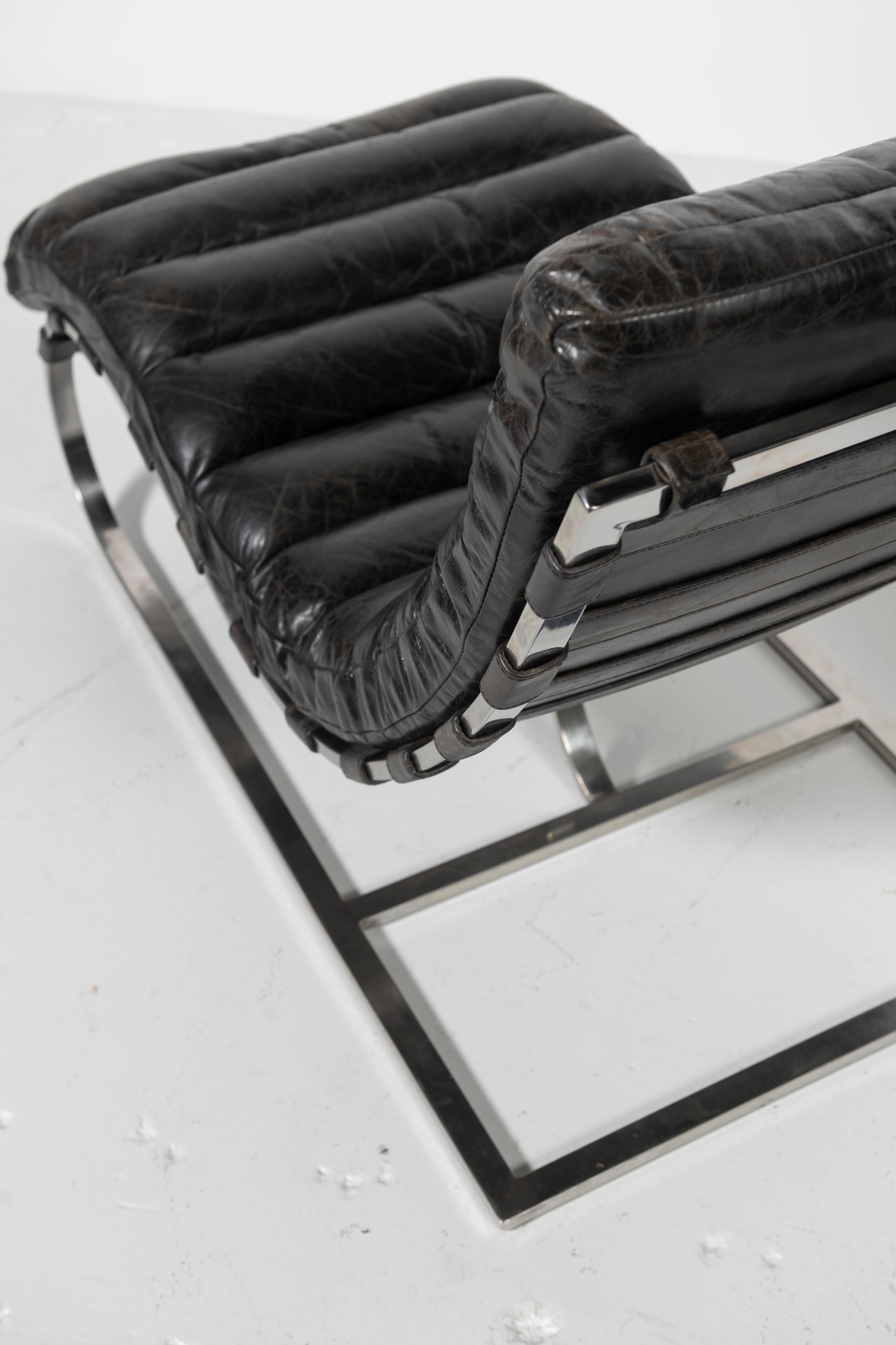 Ein Paar wunderschön abgenutzter schwarzer Ledersessel, die dem Designer Michel Boyer aus Frankreich zugeschrieben werden. Die kanalisierten Lederkissen schweben auf einem polierten Chromgestell mit Lederriemen. Klassisches Design und Komfort