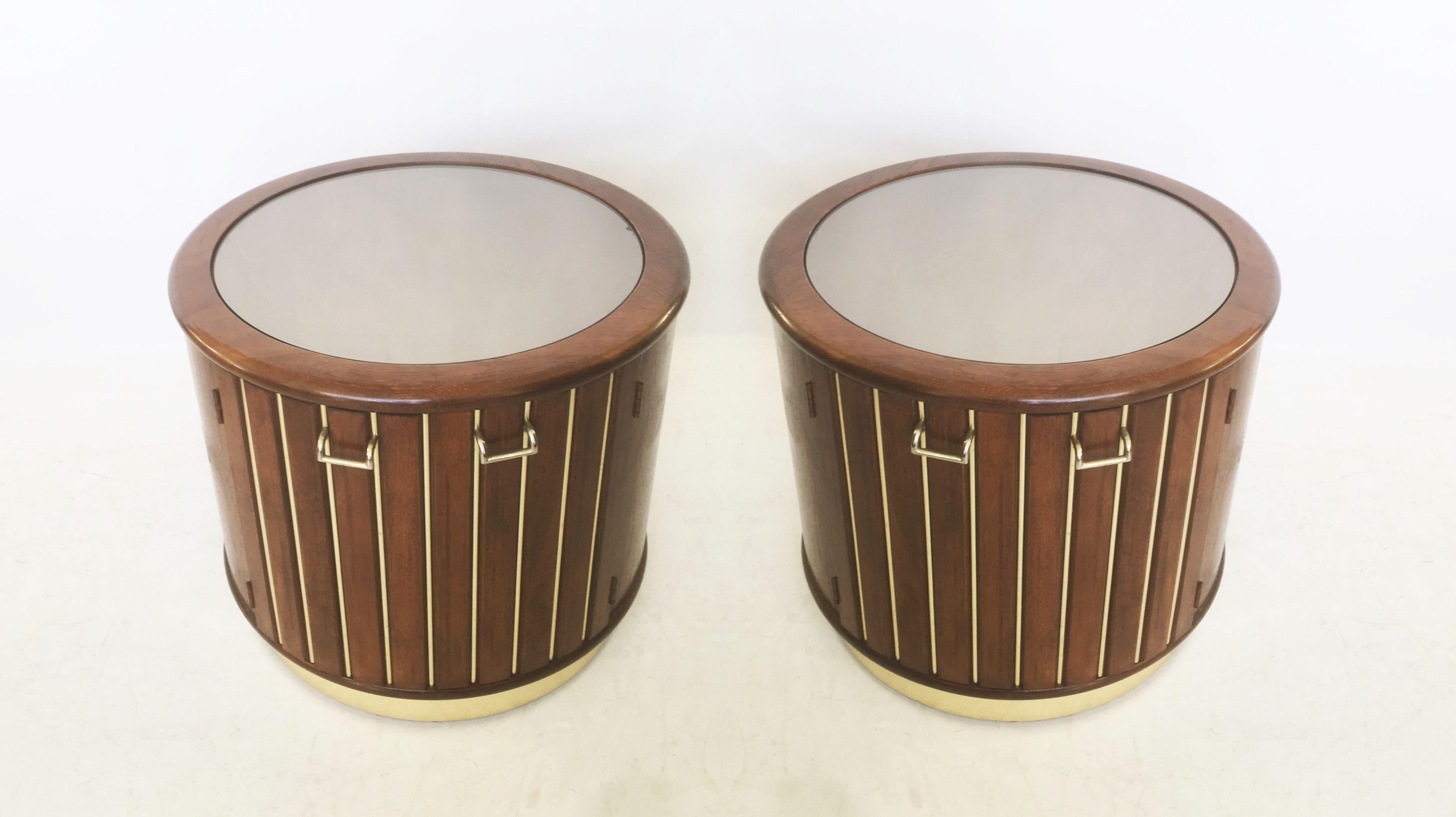 A fabulous restored pair of midcentury modern cocktail bar cabinets or side tables by American of Martinsville, circa 1980s. Made of solid wood construction, the drum-form case features a round top with mirror insert overhanging a cylindrical reeded