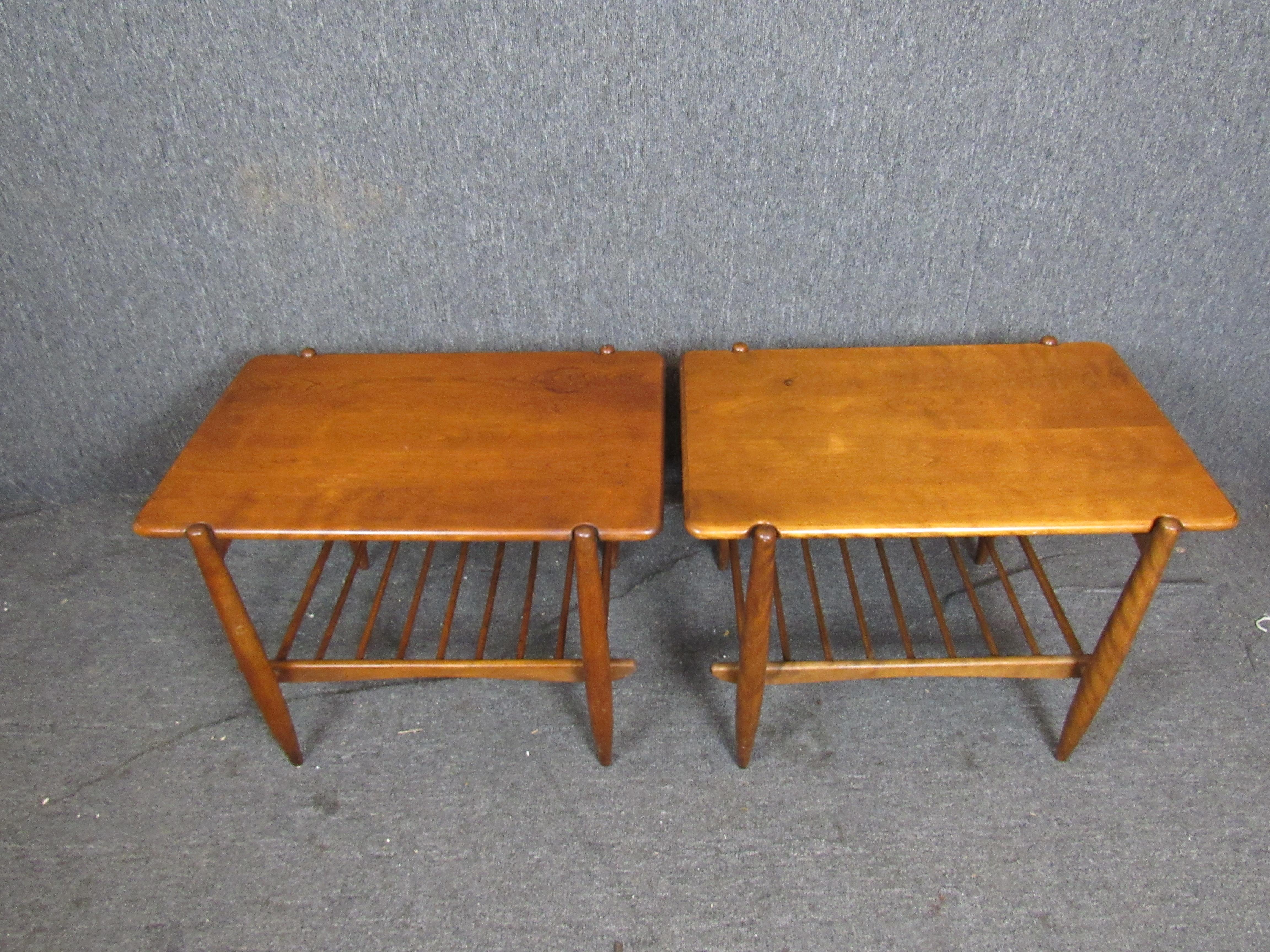 Gorgeous pair of vintage solid wood side tables made by Massachusetts' famous Conant Ball Company. Sleek tapered legs and a doweled bottom tier evoke Eastern design influences, while ample American maple table tops offer versatility in use. 
Please