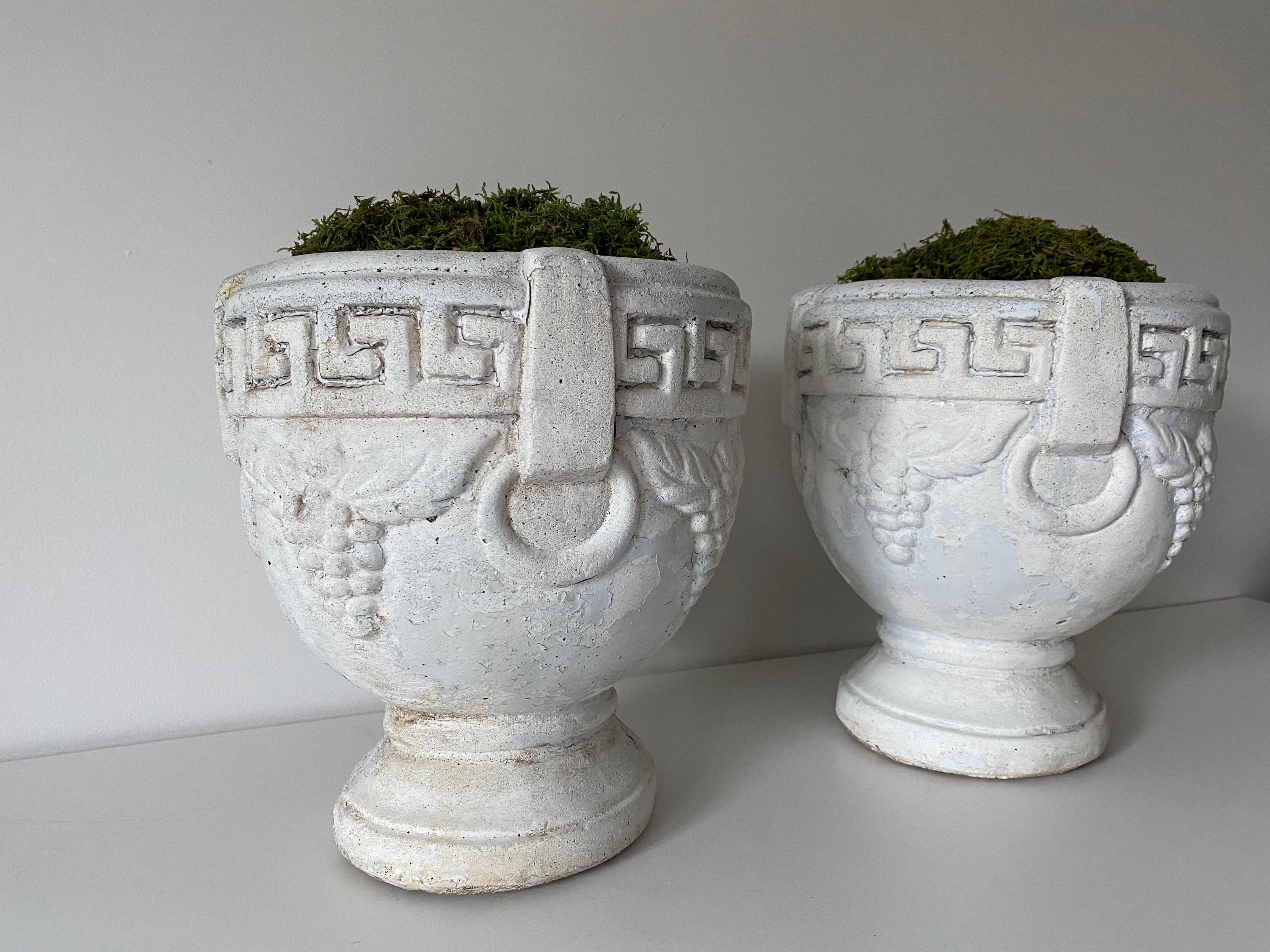 Une paire de jardinières ou d'urnes vintage en béton avec une décoration en forme de clé grecque et de raisin. Merveilleuse patine partout.