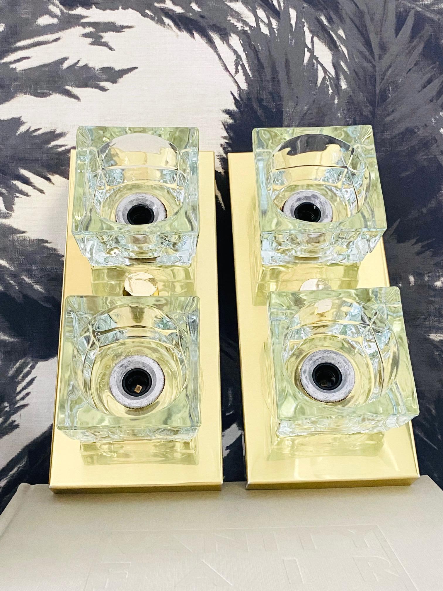 Pair of German Mid-Century Modern wall sconces with cubist design. The sconces feature brass frames with two hand-crafted cut glass shades with block forms. Frames can be mounted vertically or horizontally and have a polished brass finish.