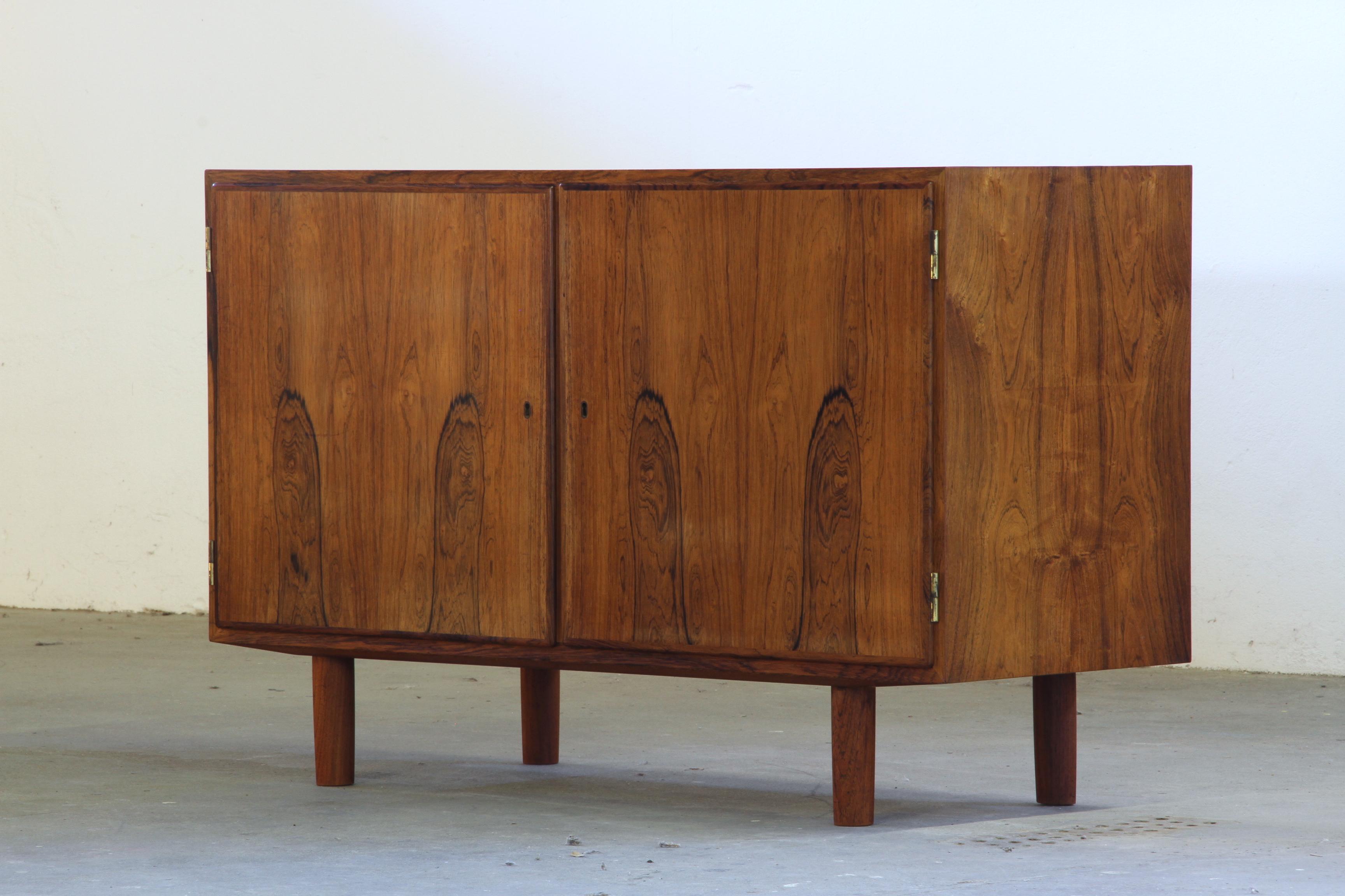 We are proud to offer these two stunning Rosewood sideboards as a matched pair. These mid-century Danish low cabinets were designed by the esteemed Poul Hundevad, whose work is highly sought after by collectors of vintage furniture. Having been