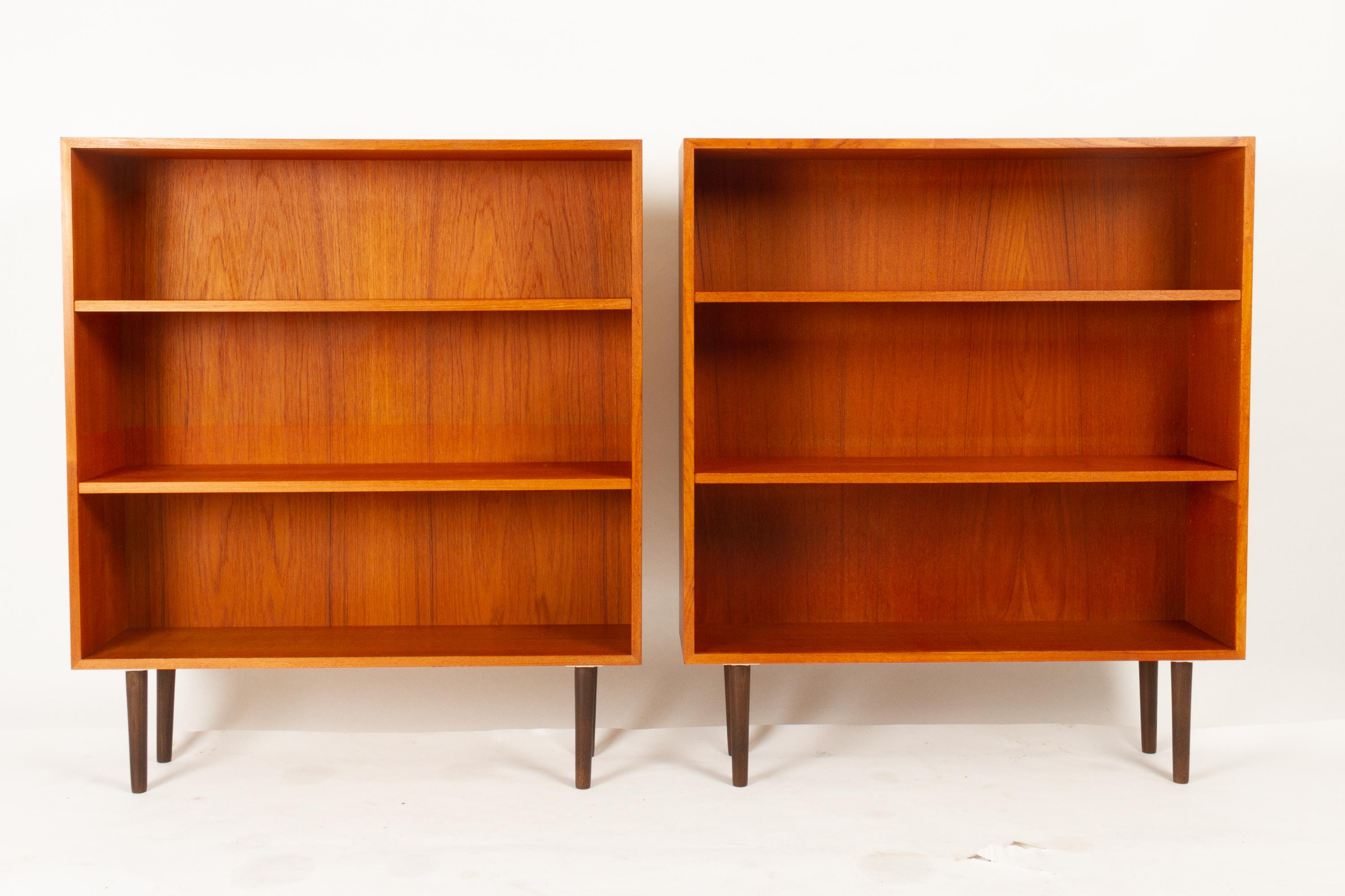 Pair of vintage Danish teak bookcases, 1960s.
Set of two matching Mid-Century Modern minimalistic bookcases in teak veneer. Each bookcase has two adjustable shelves. Standing on round tapered legs in stained oak (recent addition). Backing in teak