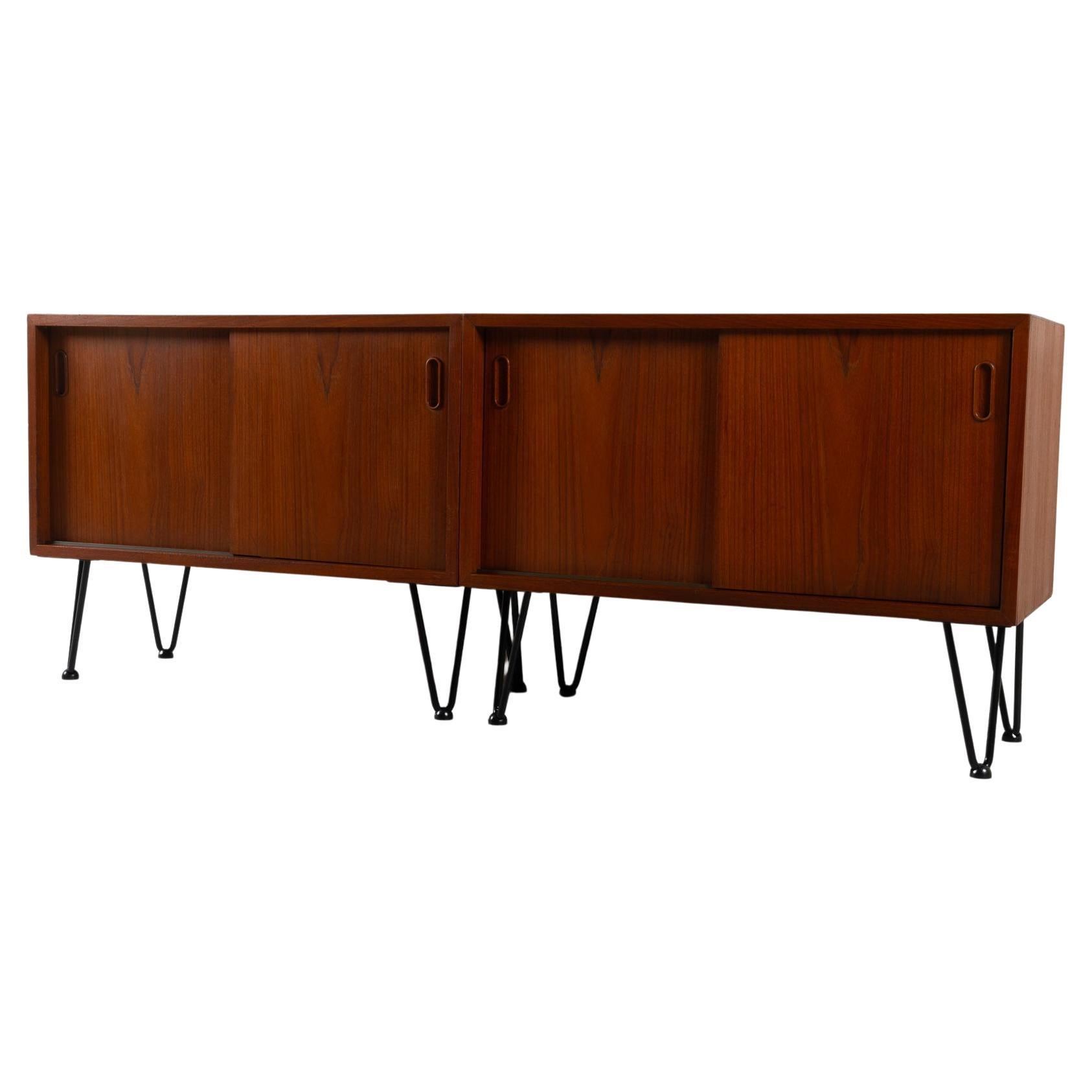 Pair of vintage Danish teak cabinets 1960s
Set of two matching teak cabinets with double sliding doors and each with one shelf. 
Can be used individually or together as a long low sideboard. Also suitable as bedside tables or side tables. 

Good