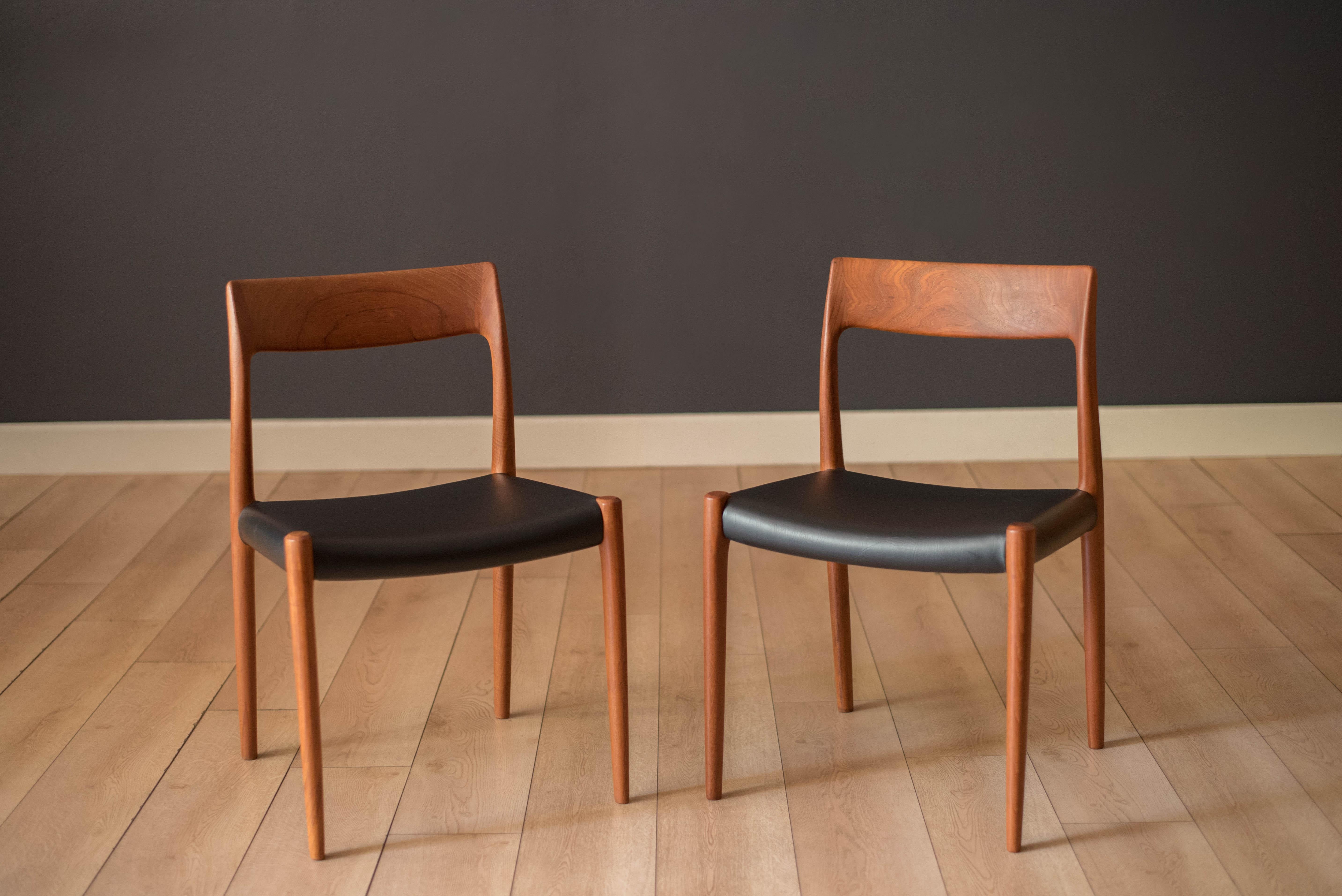 Pair of Mid-Century Modern dining chairs designed by Niels Otto Møller for J.L. Møller Møbelfabrik, Denmark. Features sculpted teak frames and seats have been professionally reupholstered in black vinyl. Price includes the set of two.