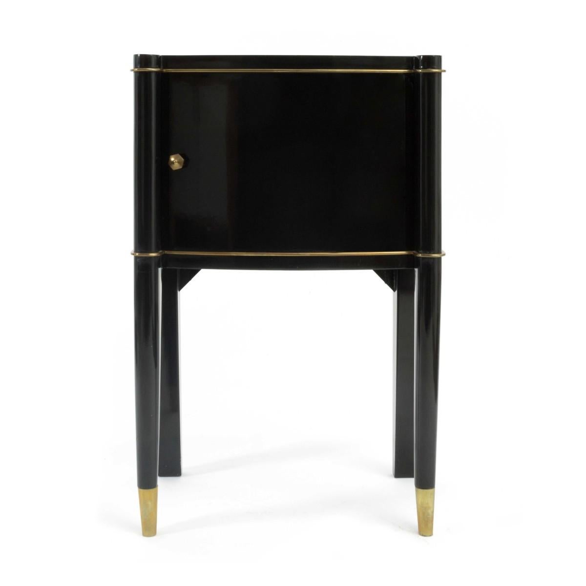 A pair of Art Deco nightstands with single right and left opening doors by De Coene Frères. Made in the 1930s in Brussels, Belgium. Signed with original label.

Featuring a black lacquer finish, sycamore interior, bronze details, sabots and center