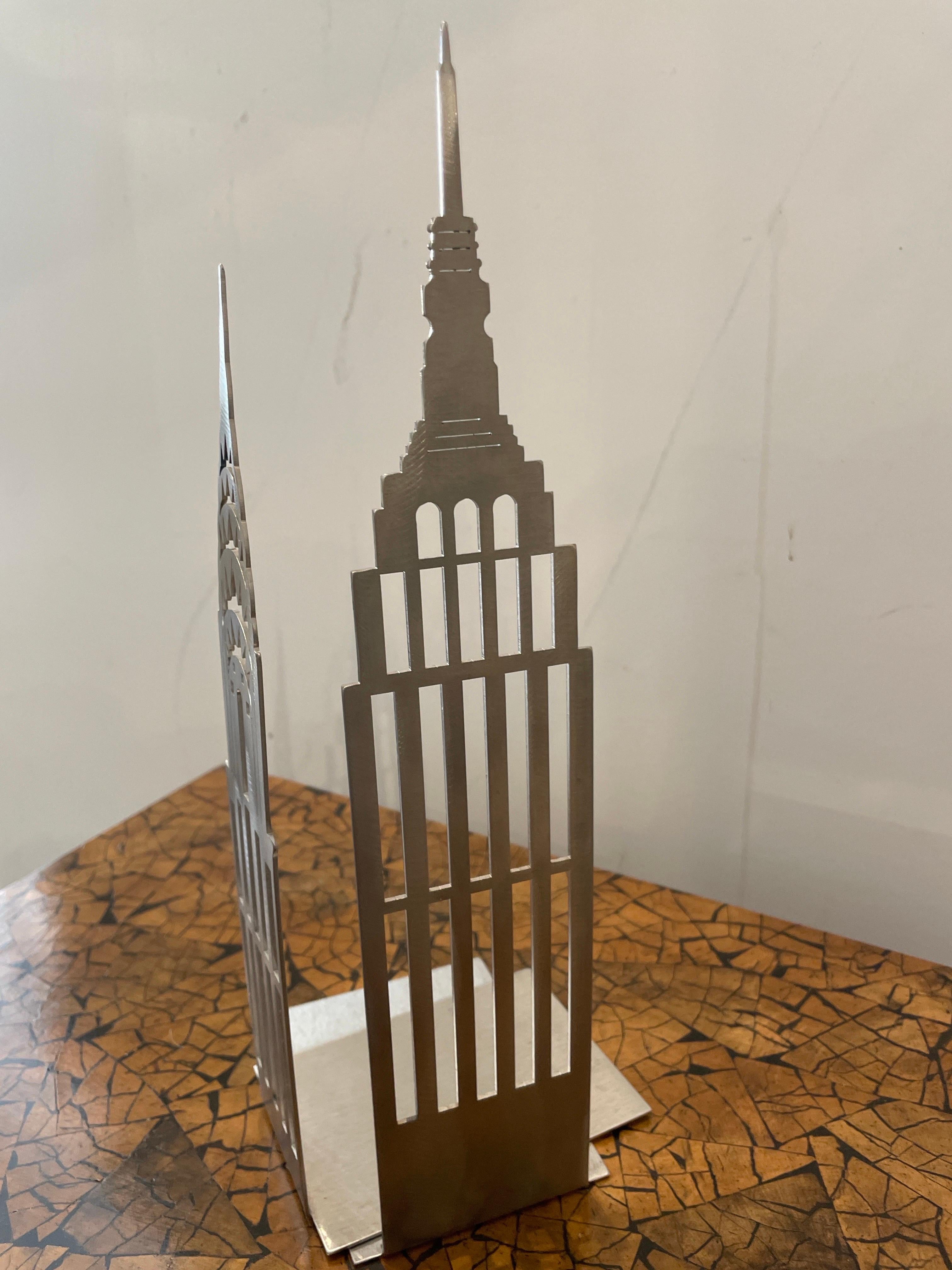 Pair of cut out metal sculptures of the Chrysler and Empire State Building used as bookends. A very unique and wonderful pair.