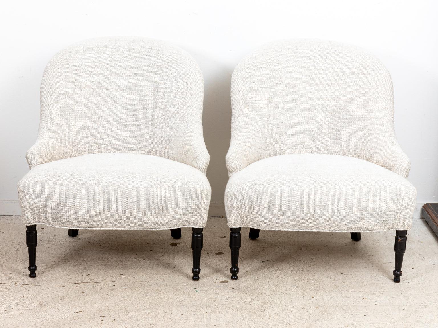 Circa 1940s pair of vintage English Country style decorated chairs with rounded seat backs, freshly upholstered in heavy linen. The chairs are also supported by ball turned, black ebonized legs. Please note of wear consistent with age.