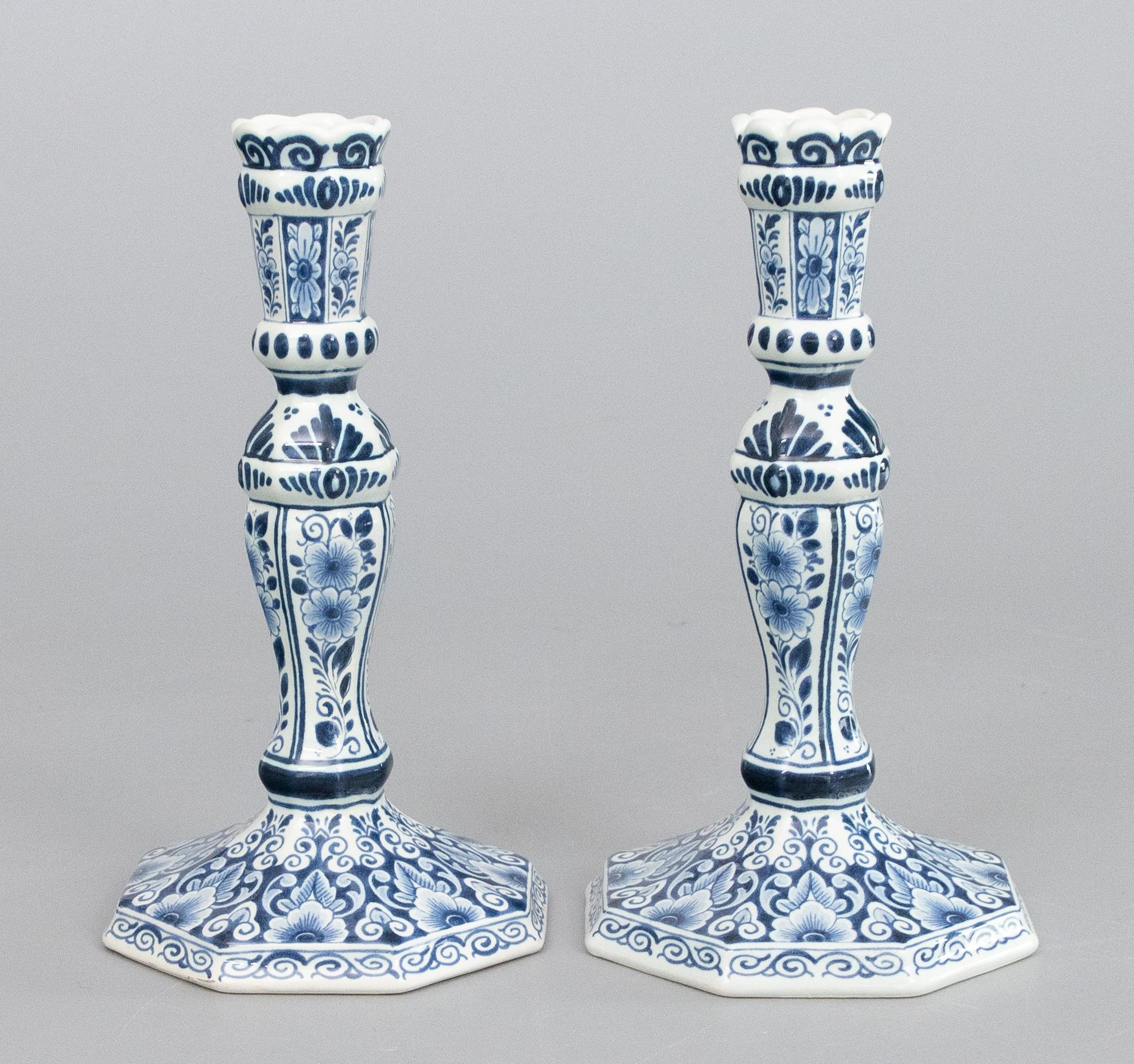 A lovely pair of Mid-Century Dutch Delft faience candlesticks. Maker's mark on reverse. These fine candlesticks are hand painted with a floral design in the traditional Delft colors of cobalt blue and white.

Dimensions
4.75ʺW × 4.75ʺD × 9ʺH