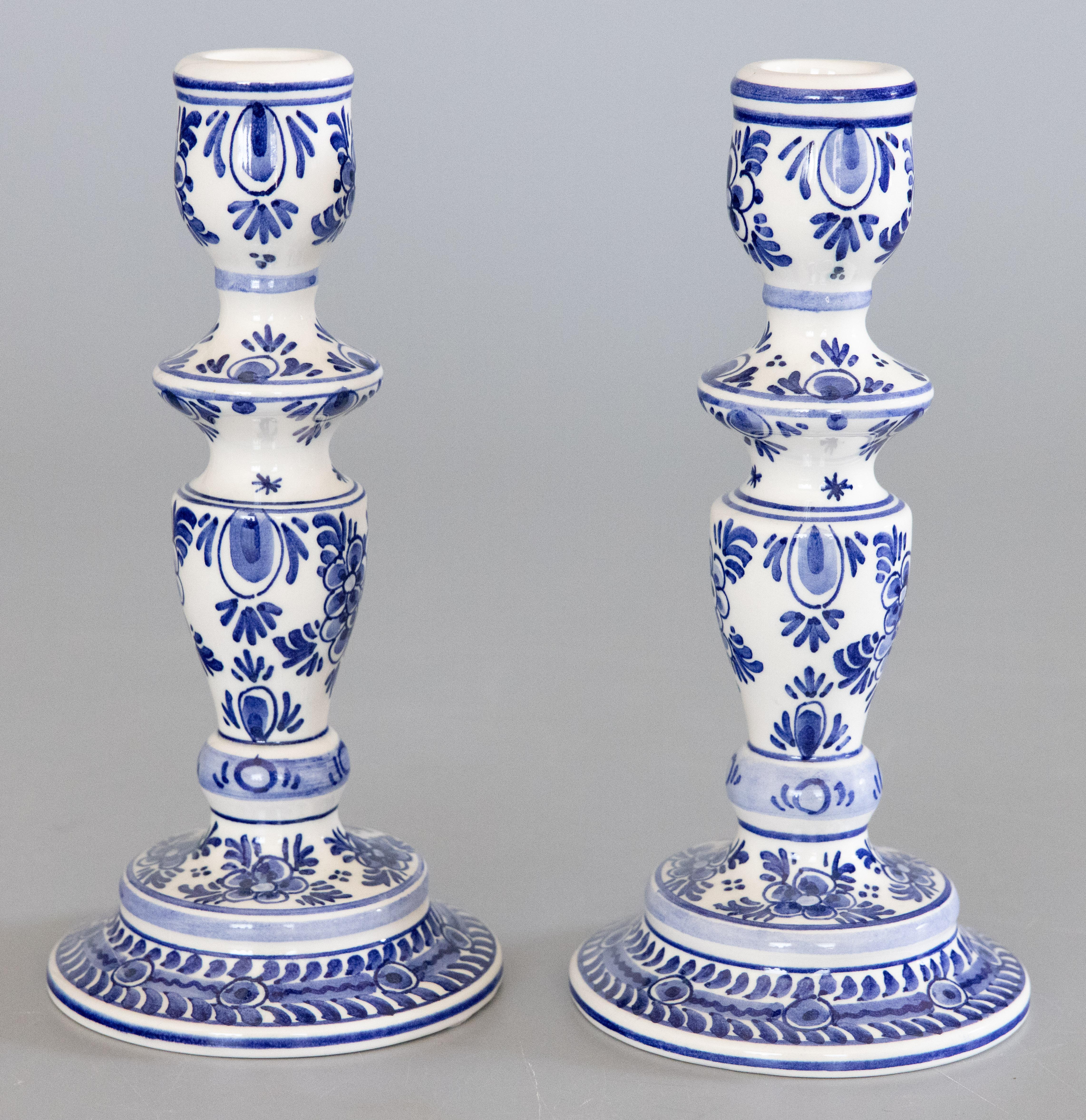 A lovely pair of Mid-Century Dutch Delft faience candlesticks. Maker's mark on reverse. These fine candlesticks are hand painted with a floral design in the traditional Delft colors of cobalt blue and white.

DIMENSIONS
4ʺW × 4ʺD × 8.25ʺH