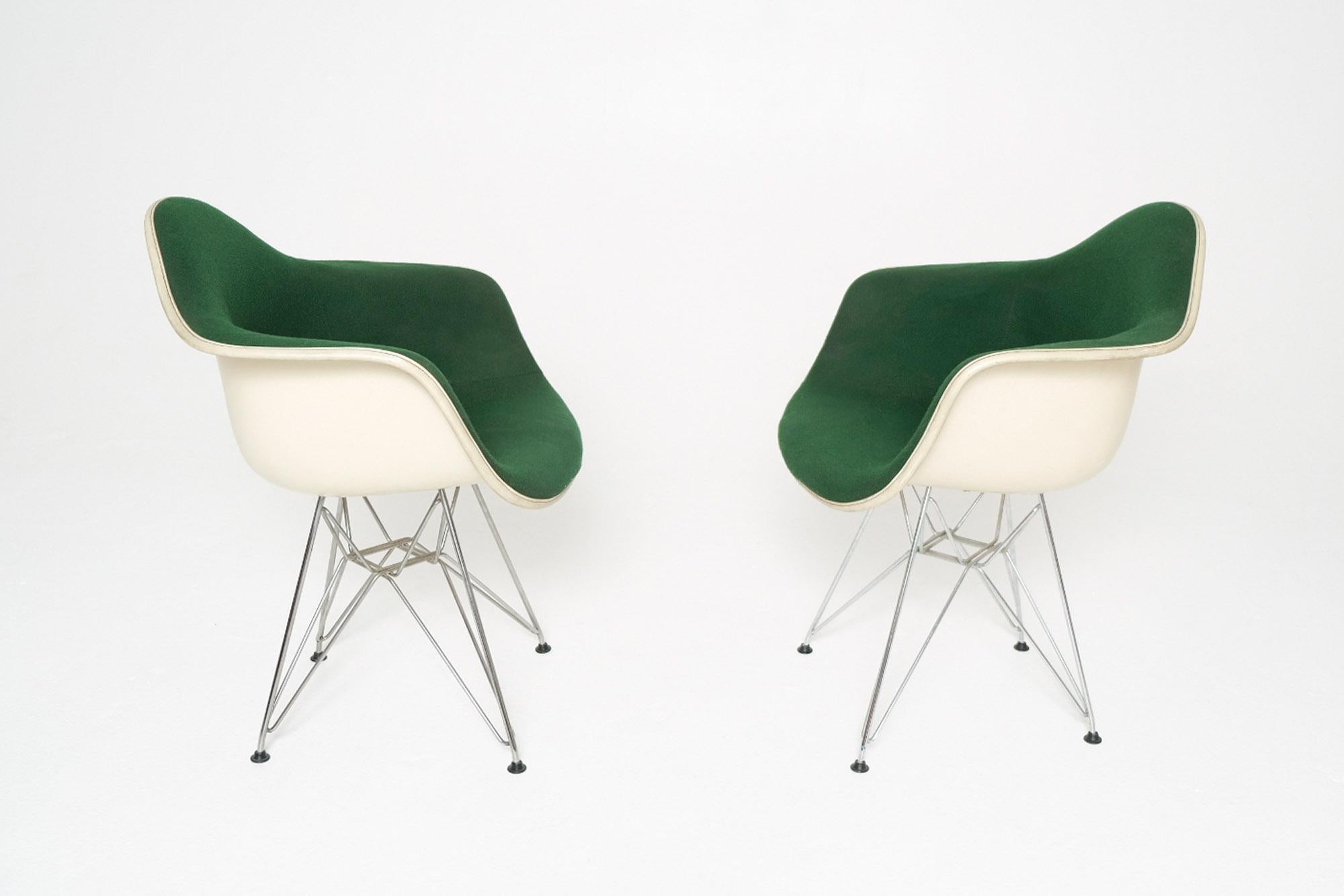 A striking pair of Eames DAR (Dining Armchair Rod Base) fiberglass armchairs designed by Charles and Ray Eames for Herman Miller, circa 1950s. These iconic Mid-Century Modern chairs feature parchment fiberglass shells with the highly sought-after