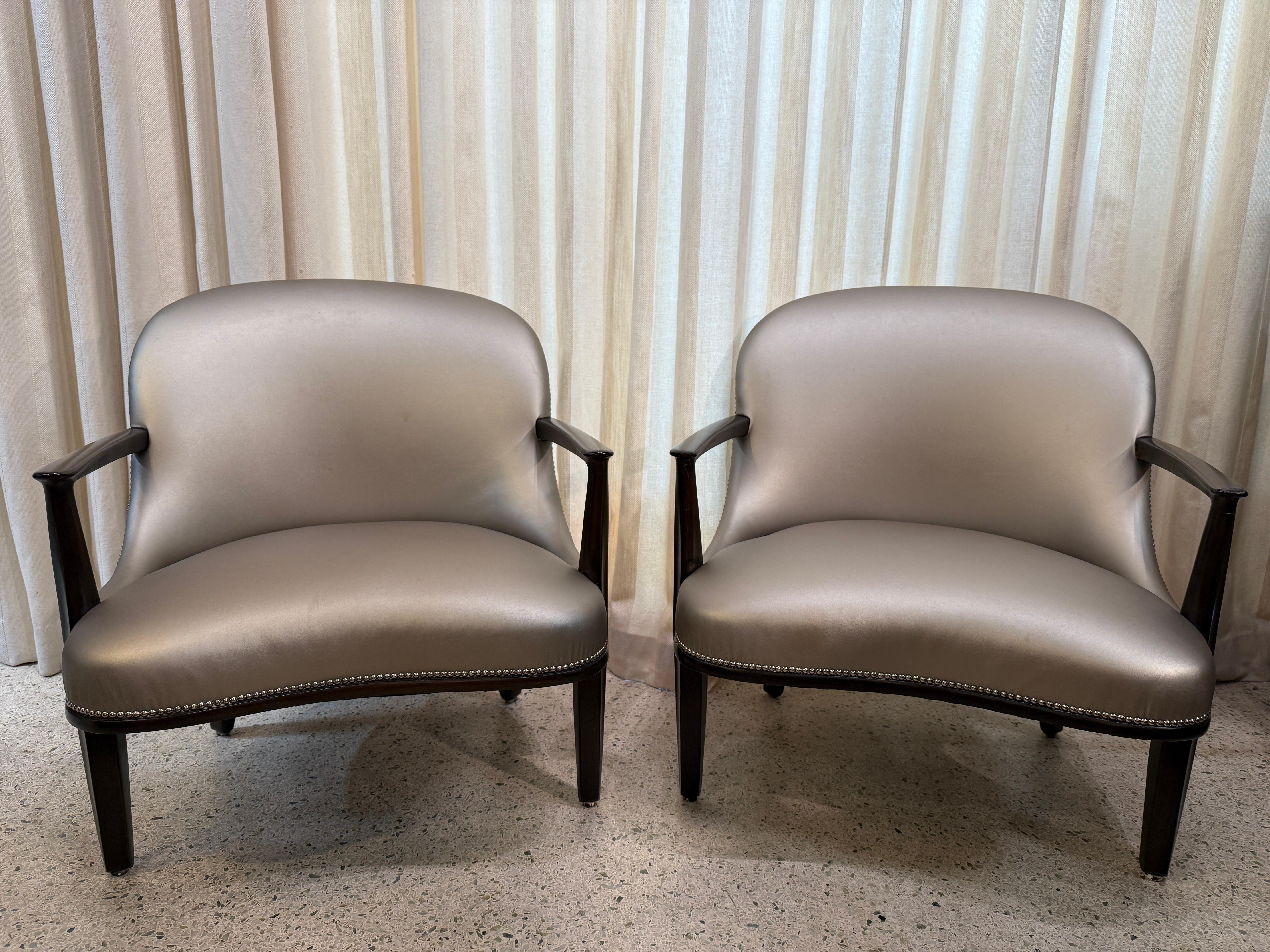 Ti presentiamo le poltrone Janus disegnate dal maestro del Mid-Century Modern Edward Wormley per Dunbar Furniture Company. Queste poltrone sono caratterizzate da una struttura scolpita in mogano scuro e da una pelle vegana metallizzata con