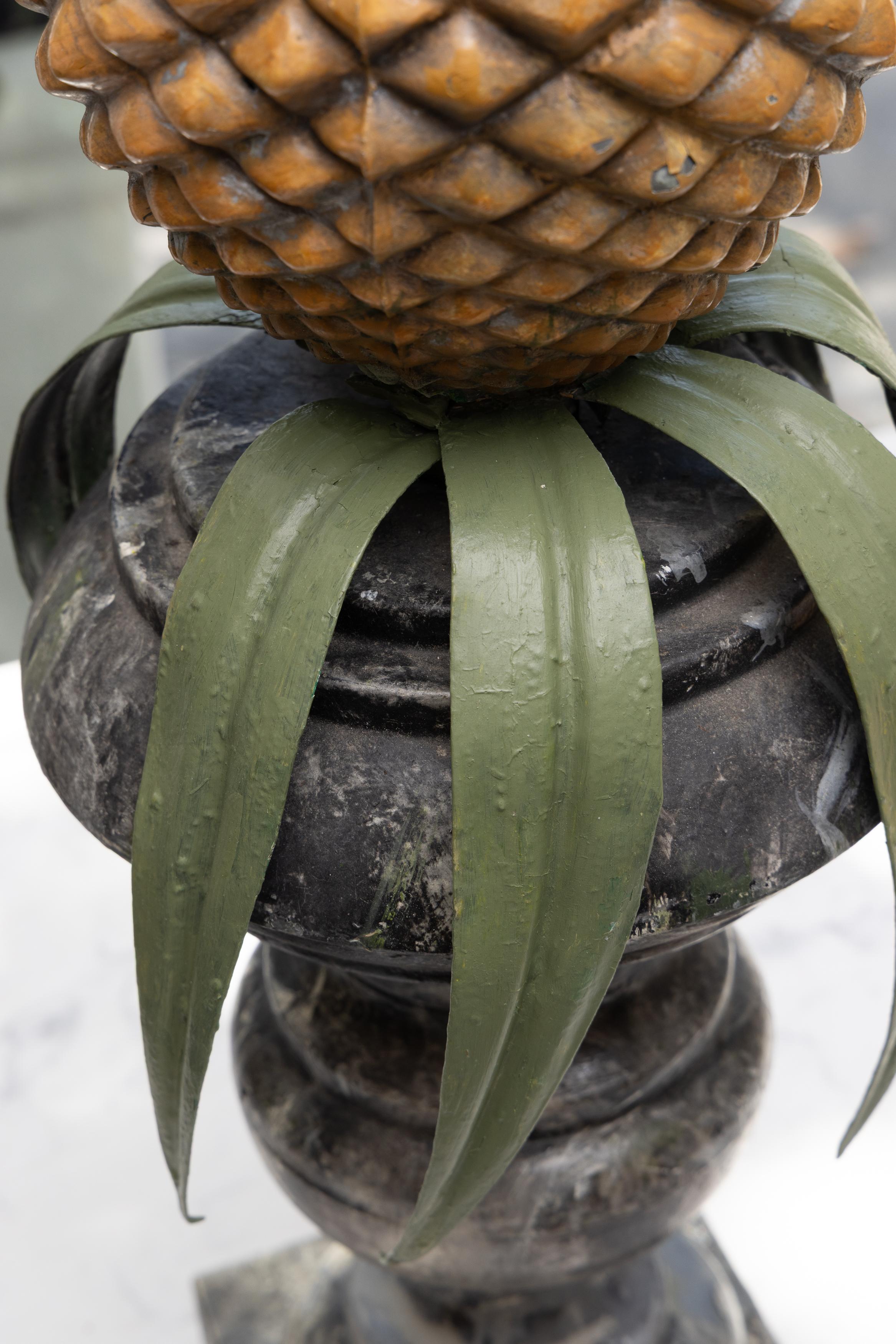 Si tratta di una coppia di lampade a tole inglesi del XIX secolo che raffigurano la figura di un ananas con le fronde in bella mostra.  L'intera struttura si trova in cima a un'urna di Campaigner.