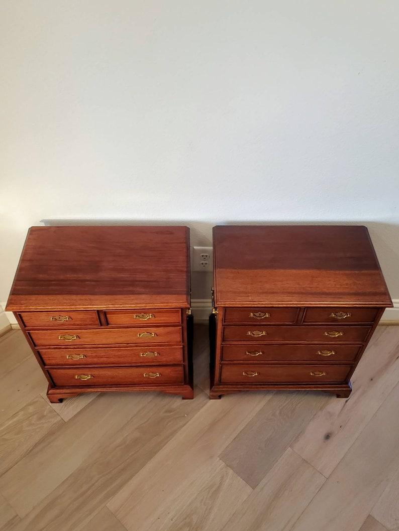A pair of vintage English Regency Campaign style mahogany petite chest of drawers, ideal for use as end tables or bedside nightstand cabinets. 

Each with made chest rectangular in shape, solid wood construction, case fitted with five drawers,